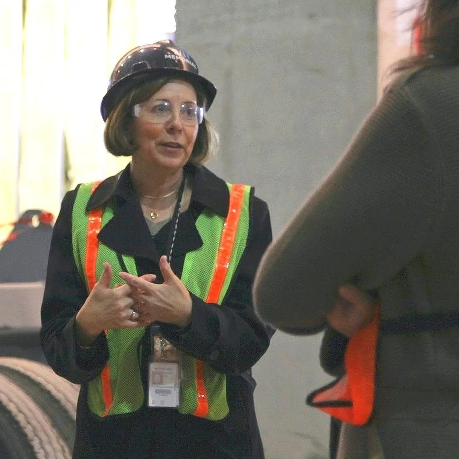 Alice M. Greenwald wearing safety glasses, a hard hat, and a high-visibility safety vest at the 9/11 Memorial &. Museum construction site.