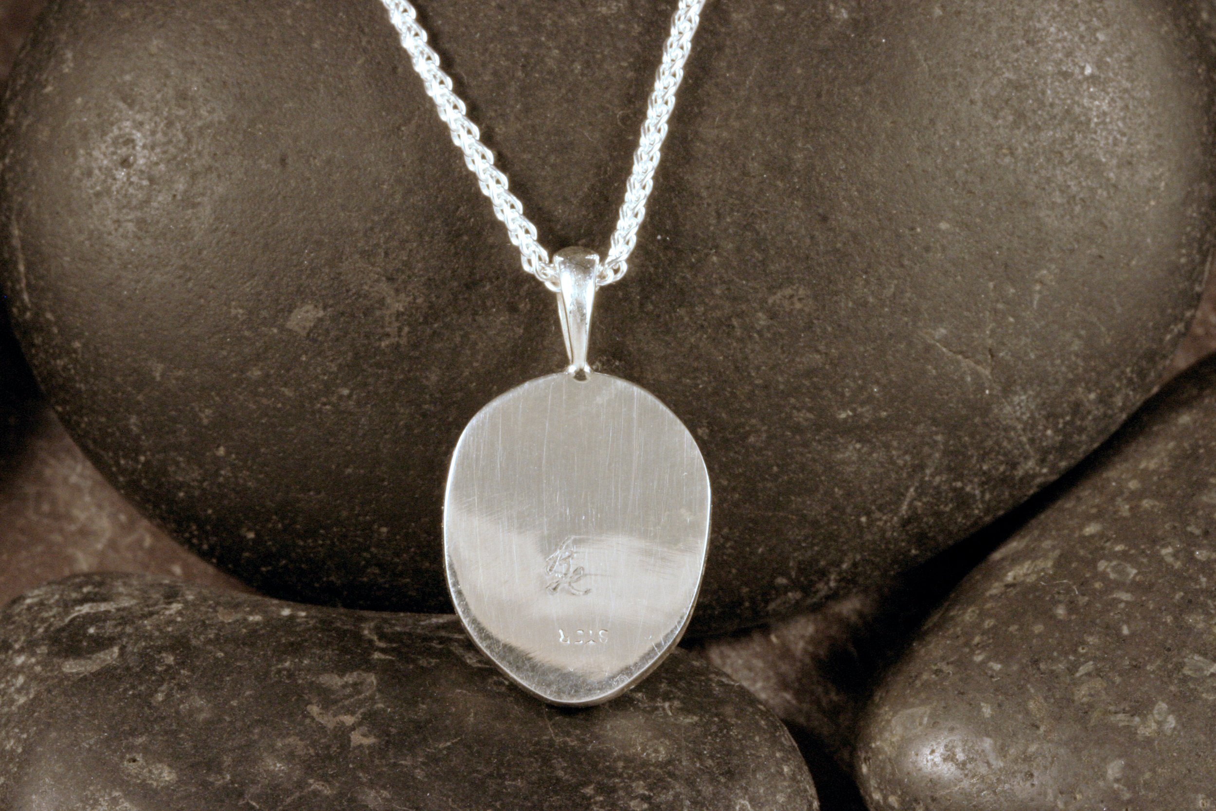 The back of a sterling silver wampum shell pendant.