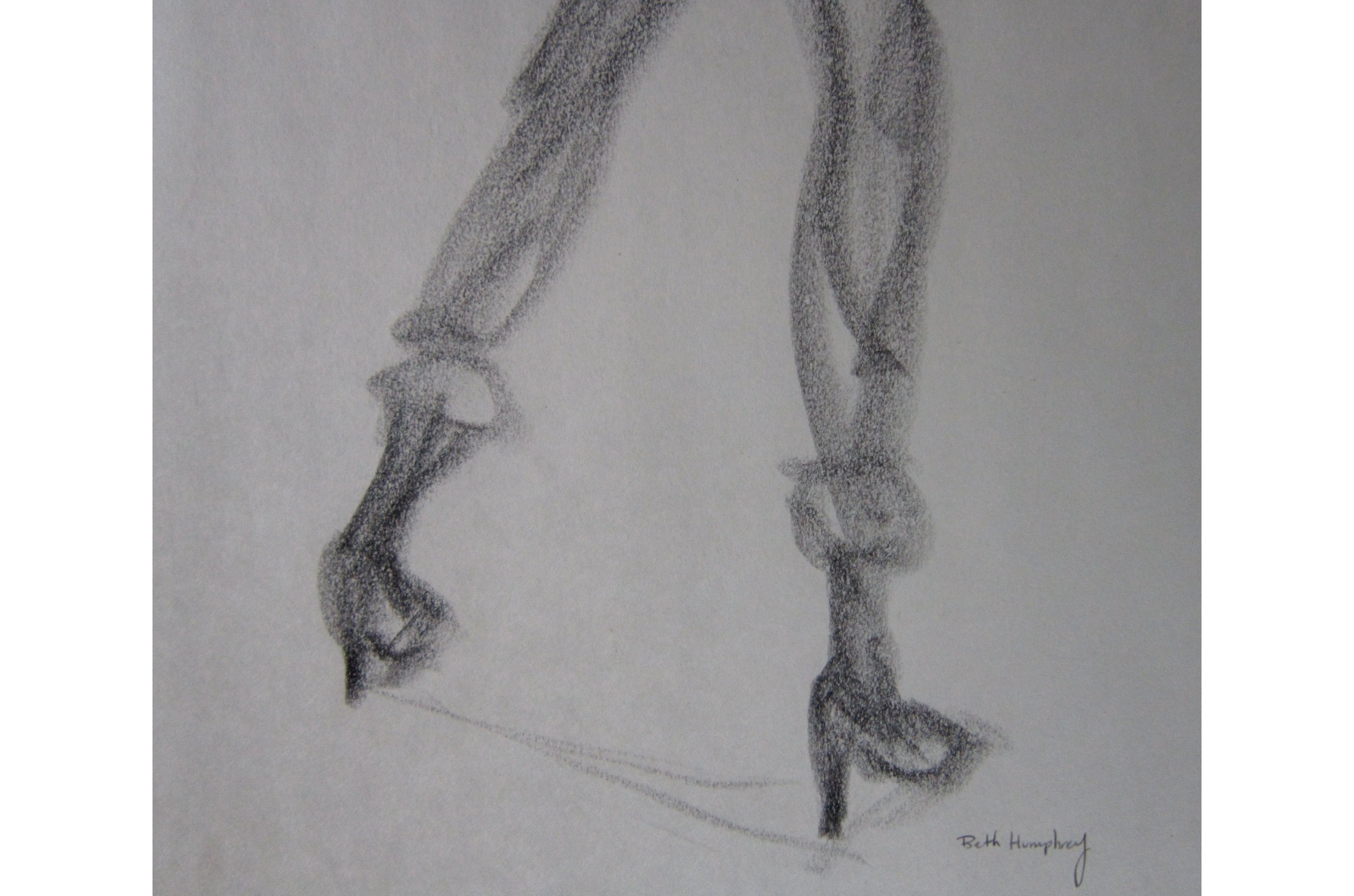 A close up of the feet in high heels on a charcoal drawing on newsprint of a classmate.
