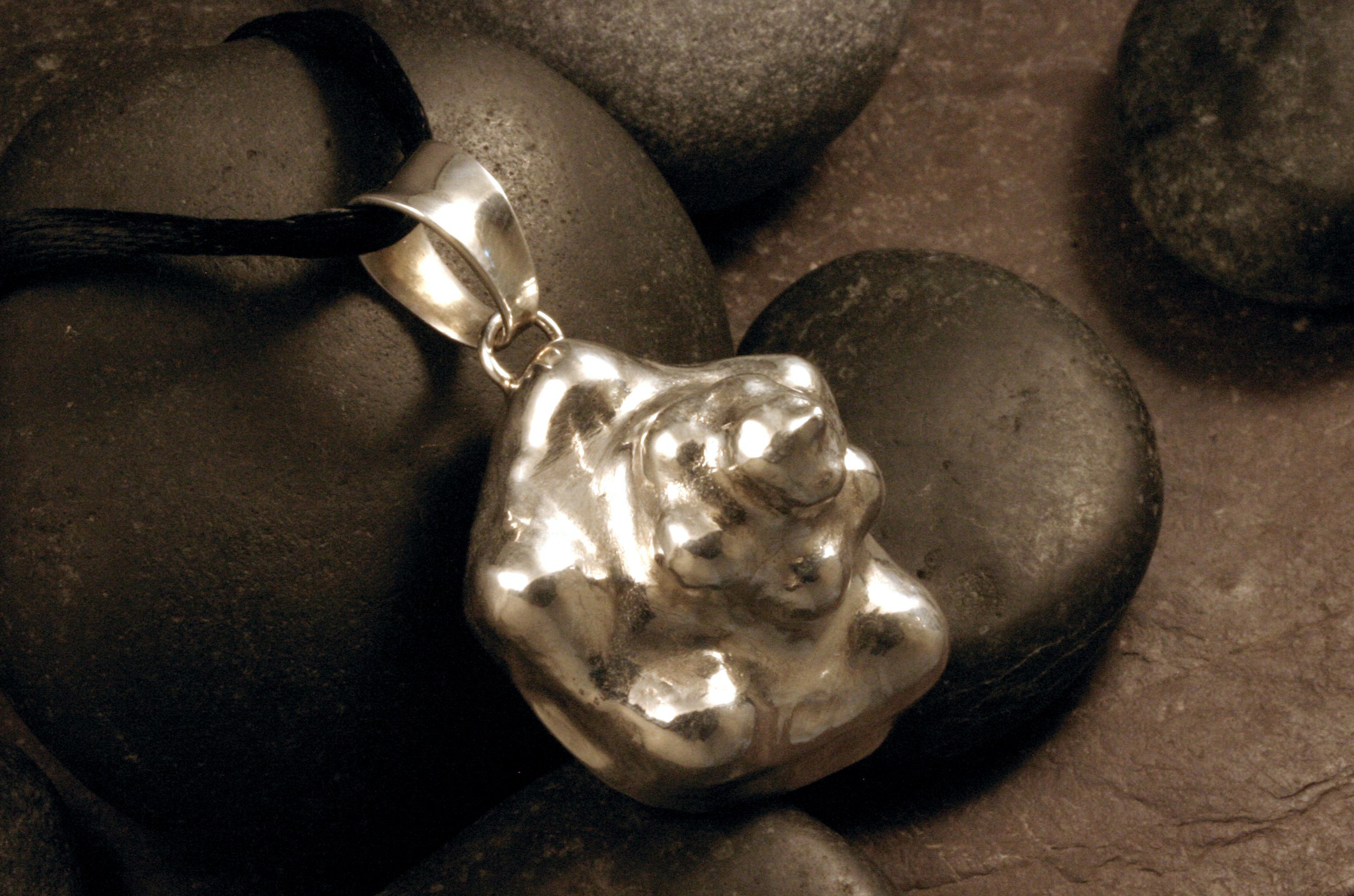 An angled view of a sterling silver large conch shell pendant.