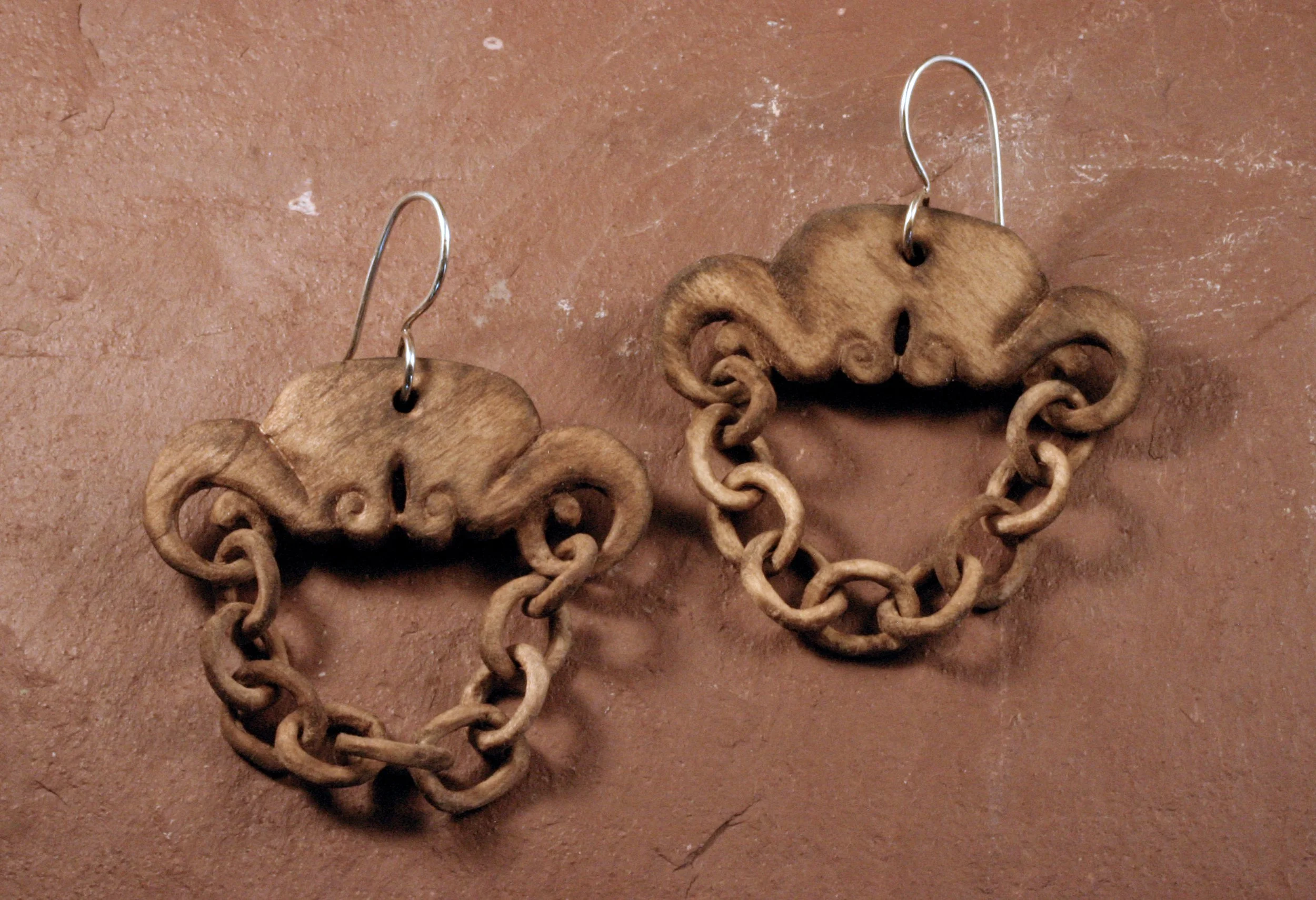 Sterling silver wood chain earrings draped on slate