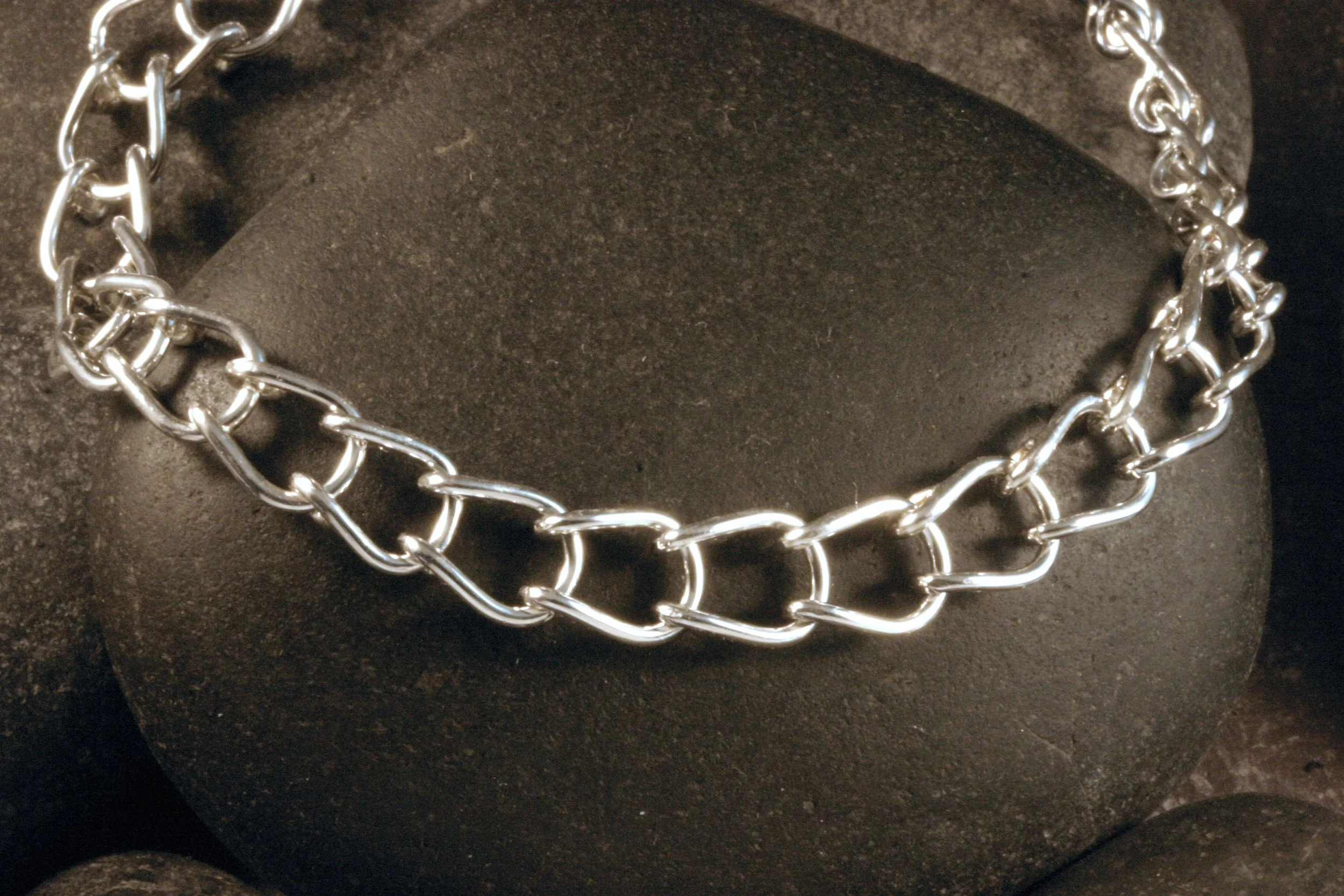 A close up of a sterling silver horseshoe shaped U link bracelet.