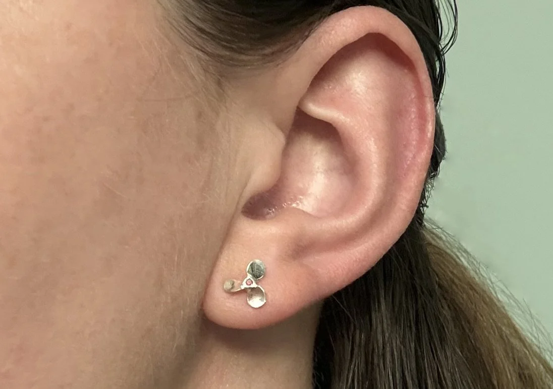 A model wearing the red port side sterling silver propeller earring