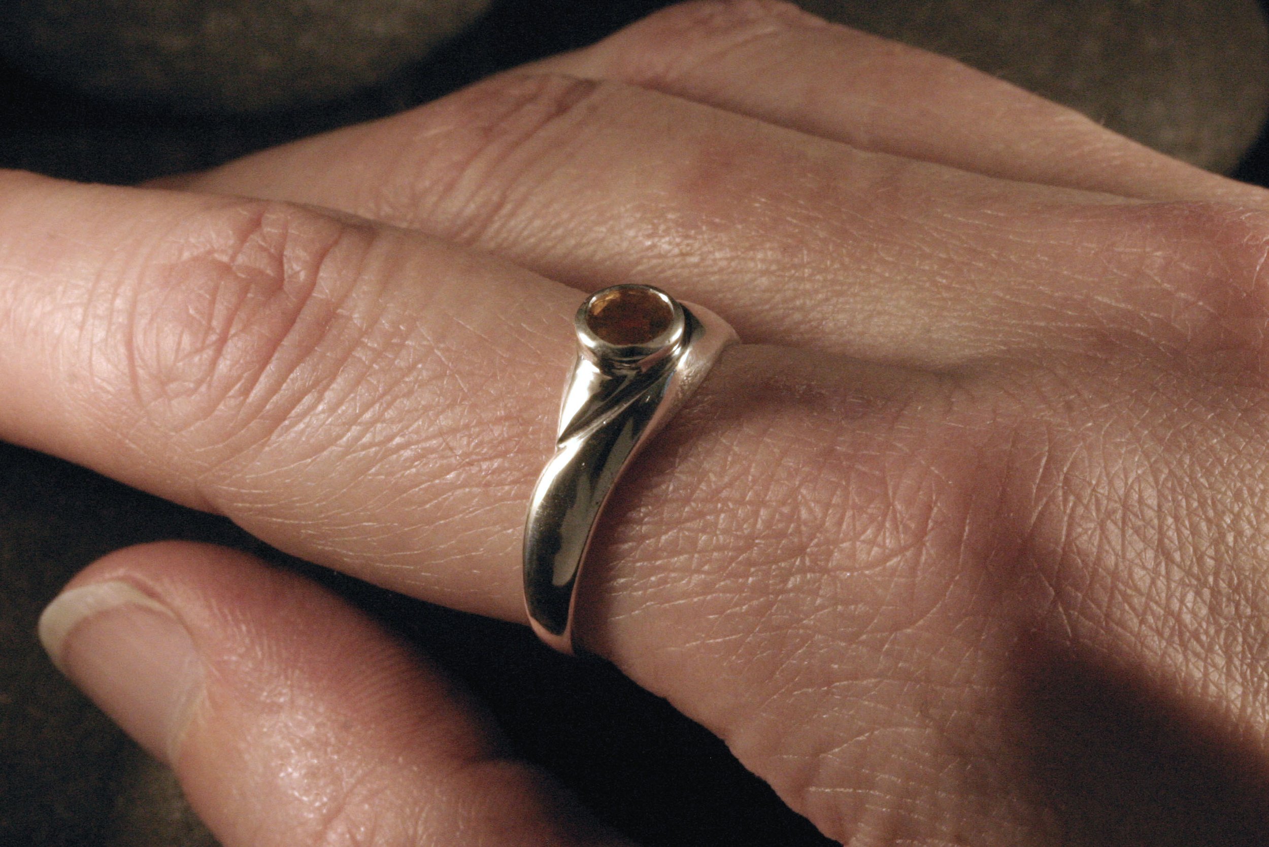 A sterling silver citrine organic v ring on a model.