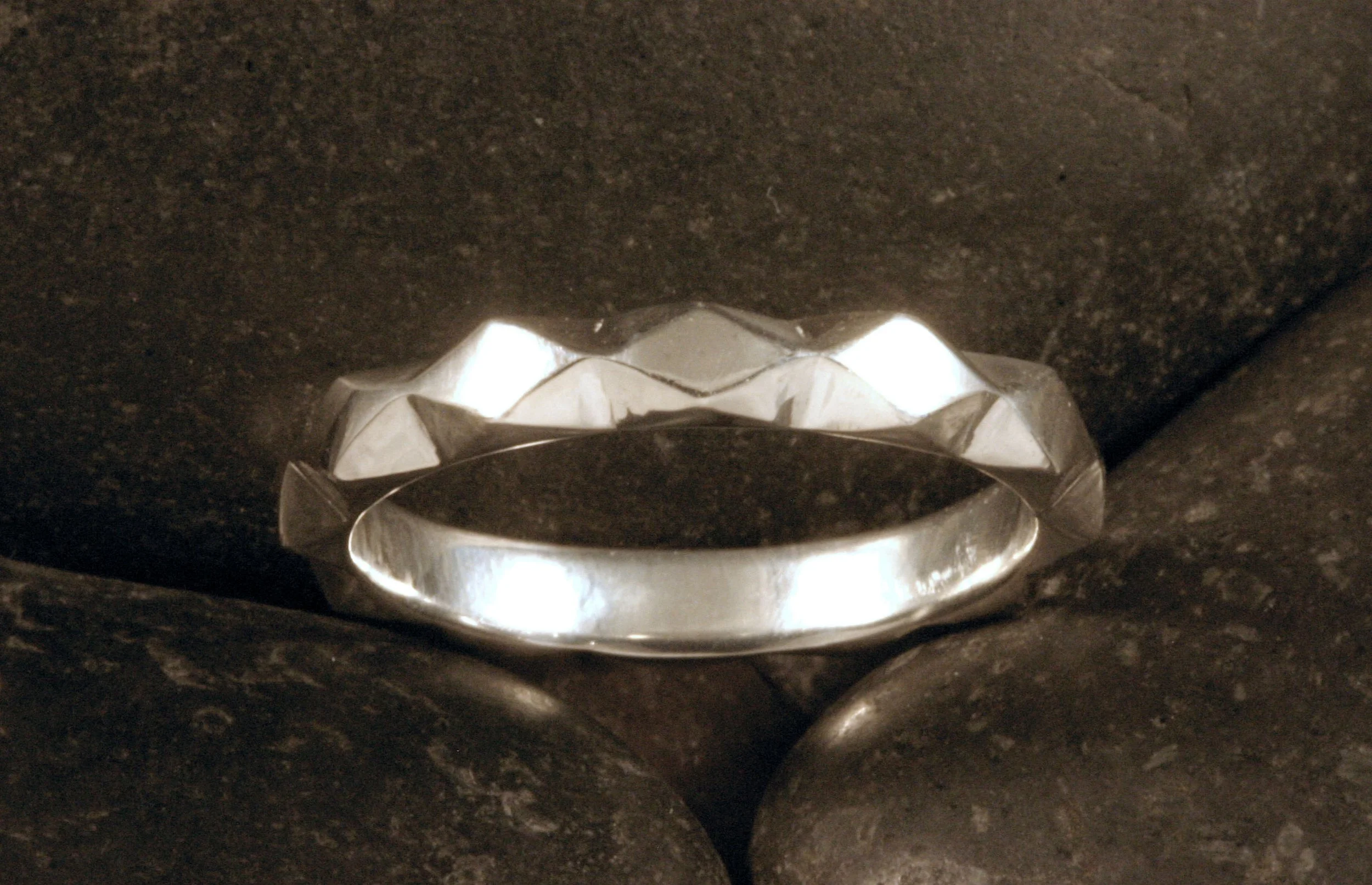 A sterling silver triangle and diamond geometric patterned ring.