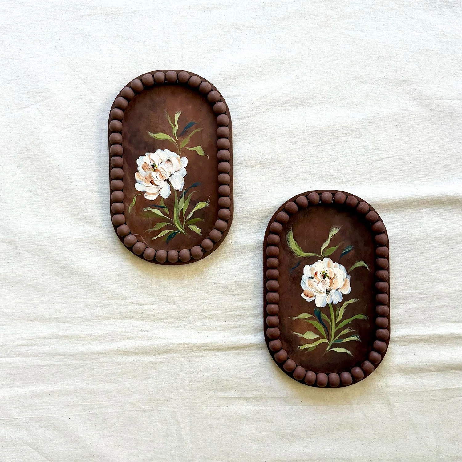 Diptych of two 5x7 original moody floral paintings with white textured petals on dark wood.