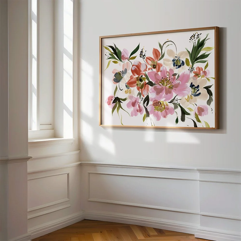 Framed botanical watercolor art with layered fall leaves underneath, set on a white surface with artist tools—highlighting the beauty of floral elegance and artisanal craftsmanship