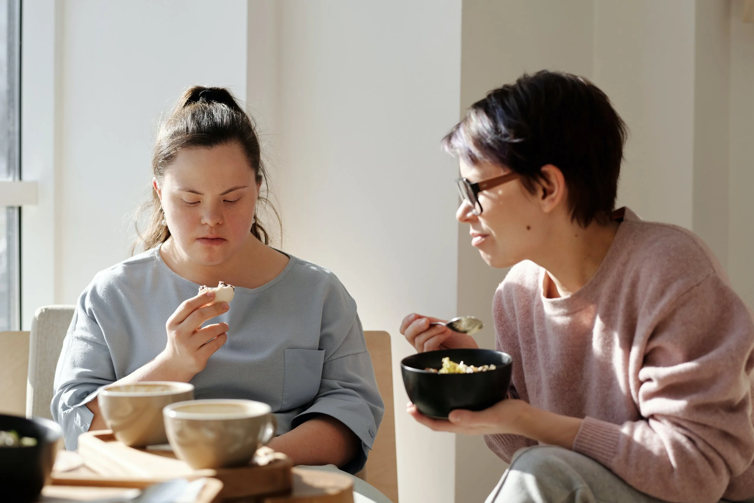 Image of disability support worker helping with daily activities such as eating breakfast.