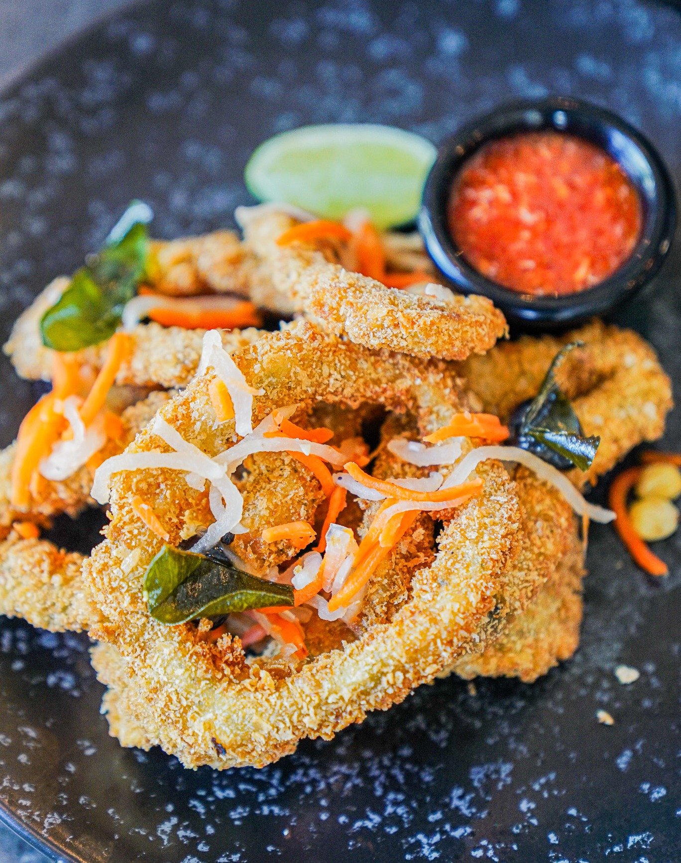 CRISPY. BOLD. EXTRAORDINARY. 🦑🔥

Tuesday cravings met. Dive into our Calamari&mdash;a vibrant signature dish that hits every note.

Tender calamari meets intense black garlic sauce, lime leaves, and toasted coconut. Finished with a sweet chilli kic