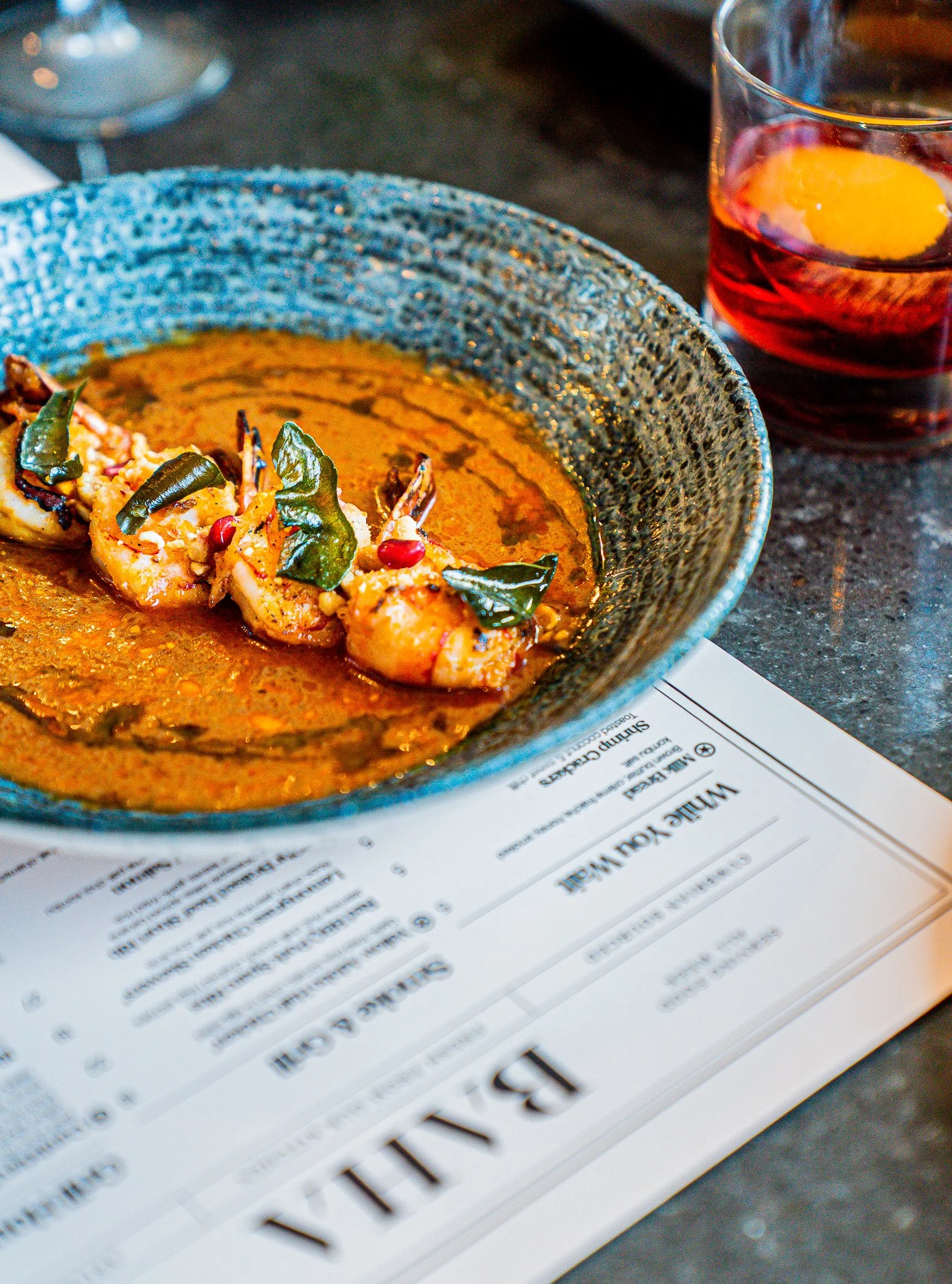 buger oozing with cheese and relish on a blue plate