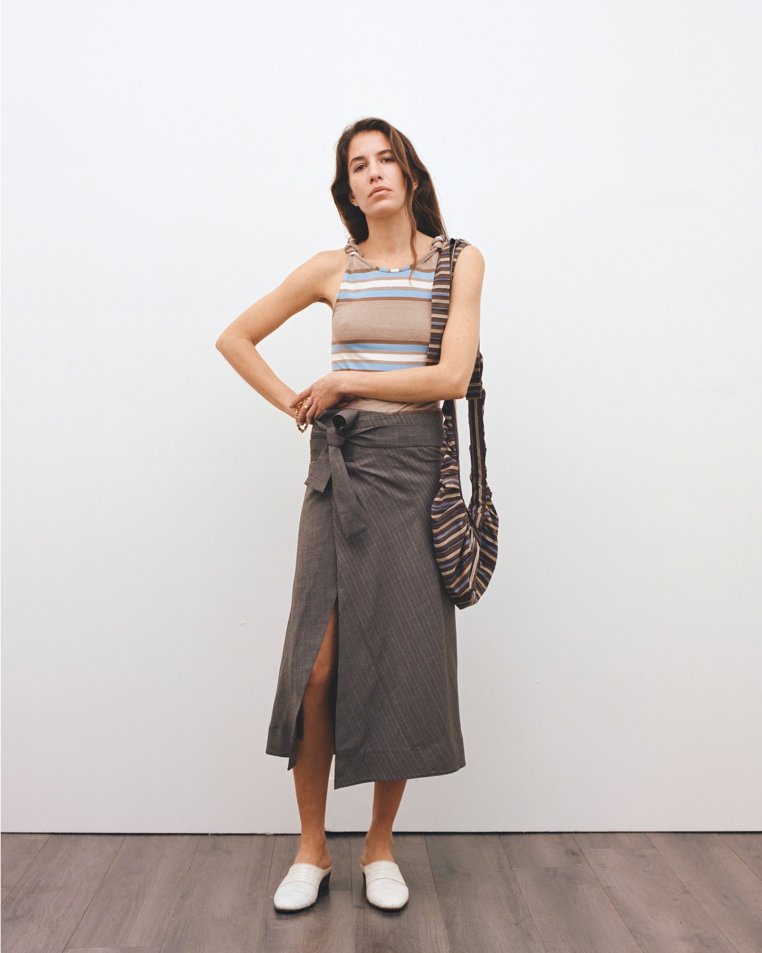 Look 11. Omaima wears the Up-cycled Wrap Skirt, Twisted Tank Top and Crash Bag, crafted from two repurposed suit trousers, one polo shirt and one long sleeve shirt sourced from Crisis UK.