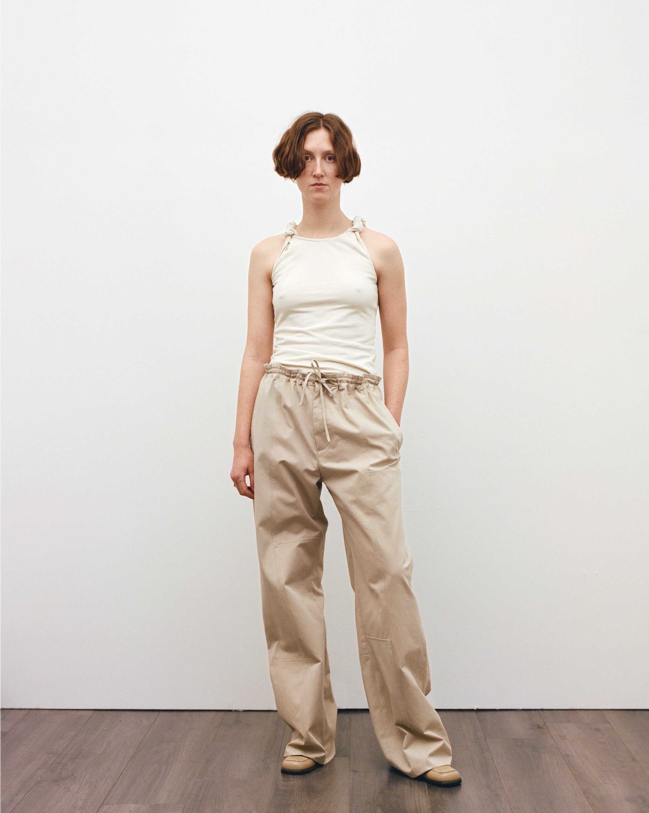 Look 4. Imogen wears the Up-cycled Twist Tank Top and Unisex Baggy Trousers, crafted from a repurposed rugby shirt and beige trousers sourced from Crisis Uk, Scope and Cancer Research Totnes
