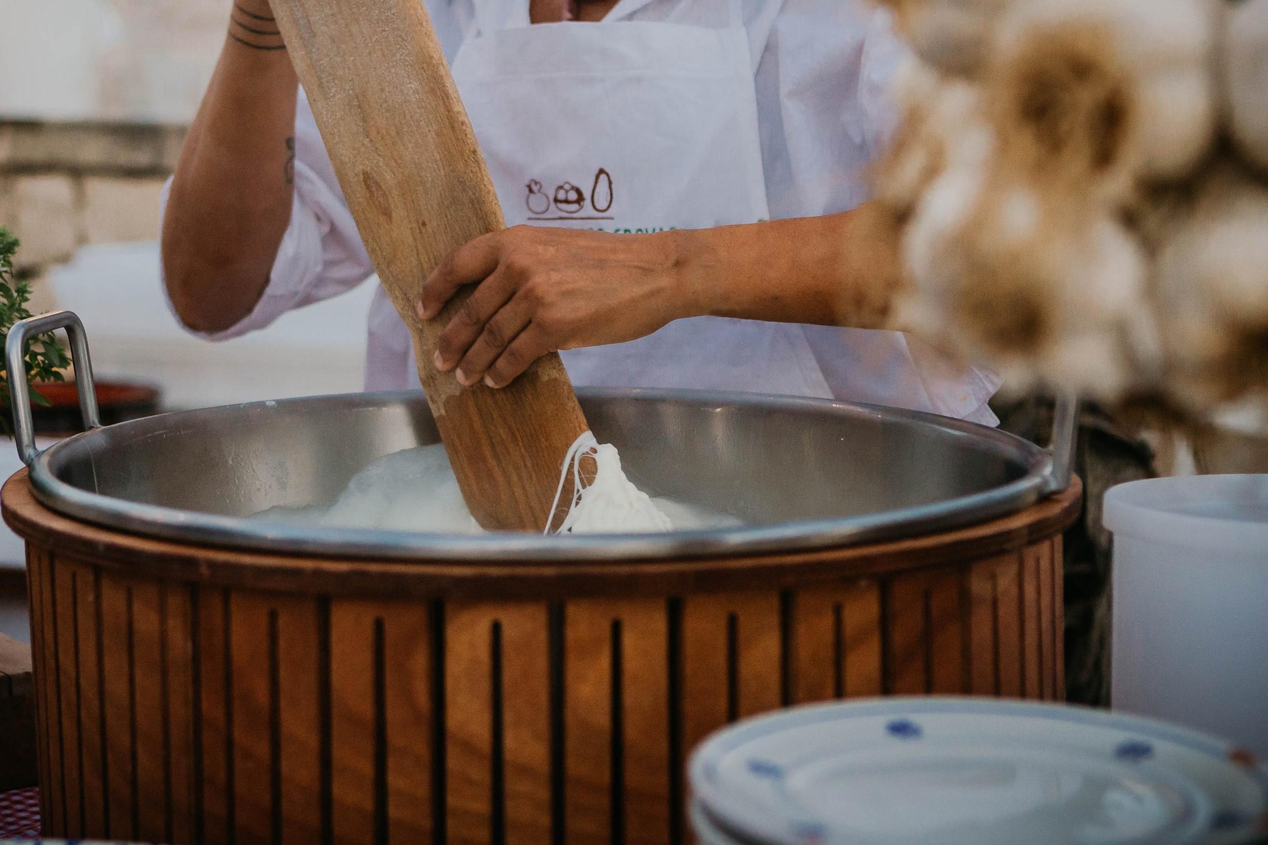 Cheesemaker stretching fresh curd by hand at a Puglia masseria