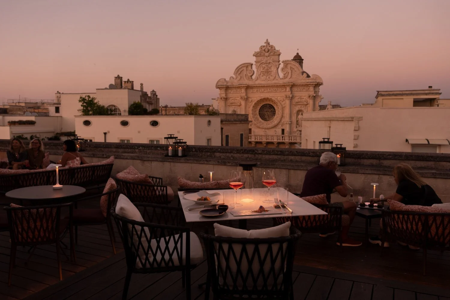 Rooftop bar at Patria Palace at dusk looking towards a Baroque church in Lecce