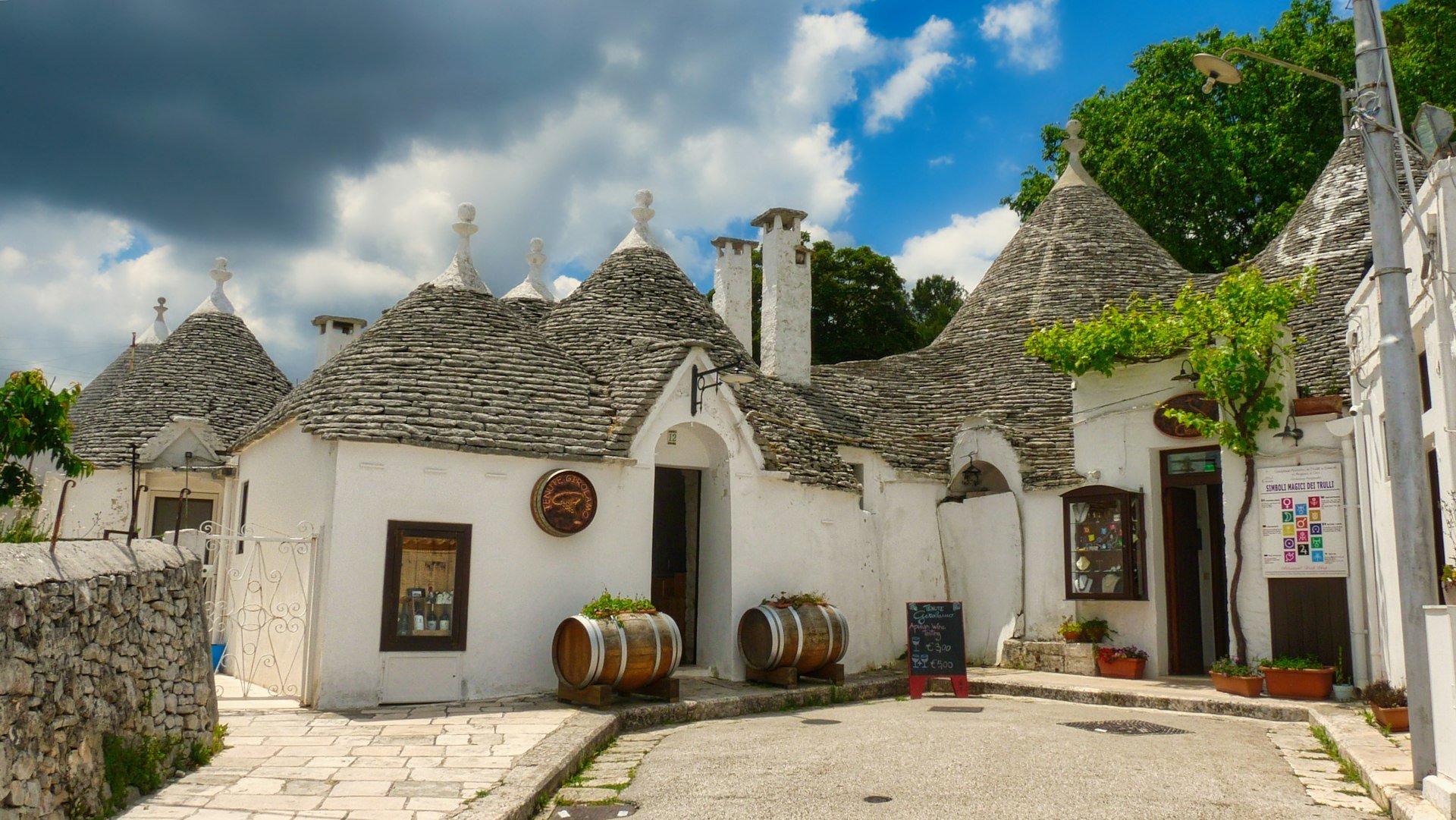 Trulli with cone-shaped stone roofs under a blue sky in Alberobello