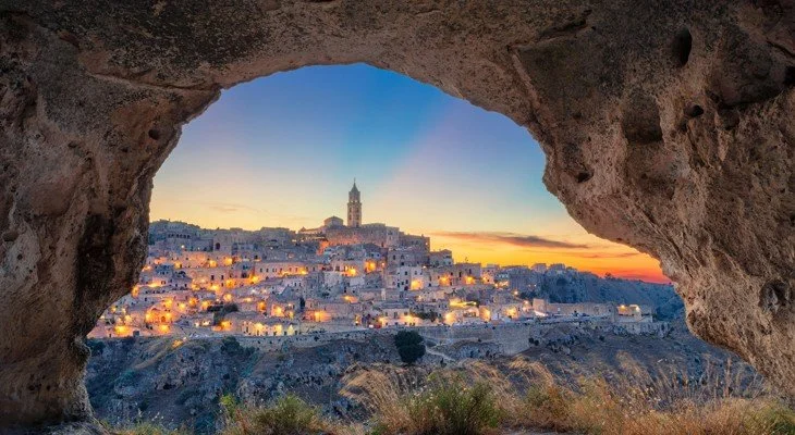 The Sassi of Matera at sunset framed by a rock-cut cave opening, Basilicata
