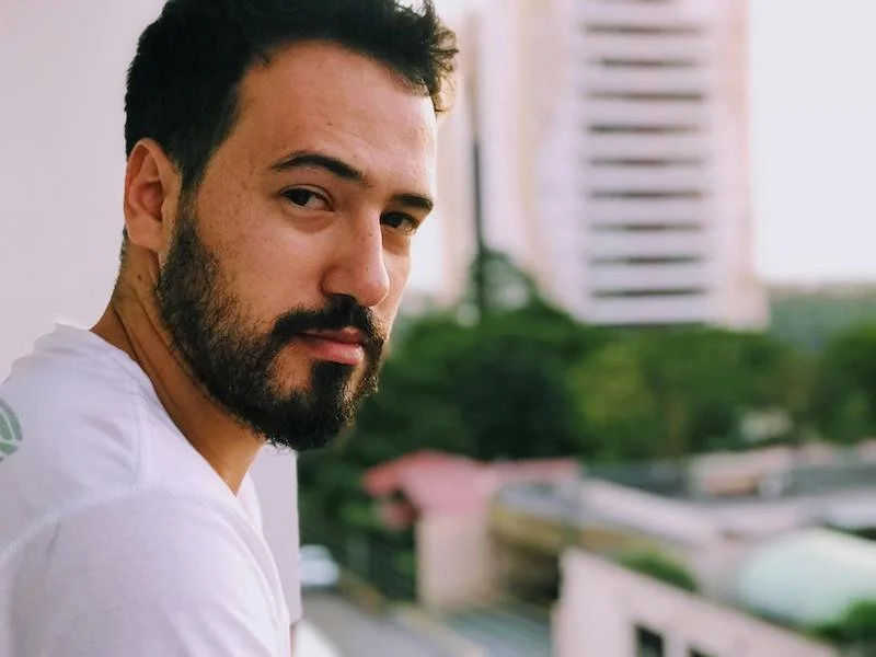 A man looking away off a balcony