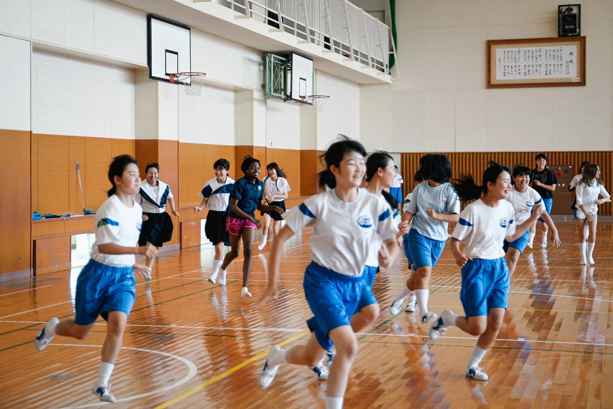 American and Japanese students running in a gym in Japan