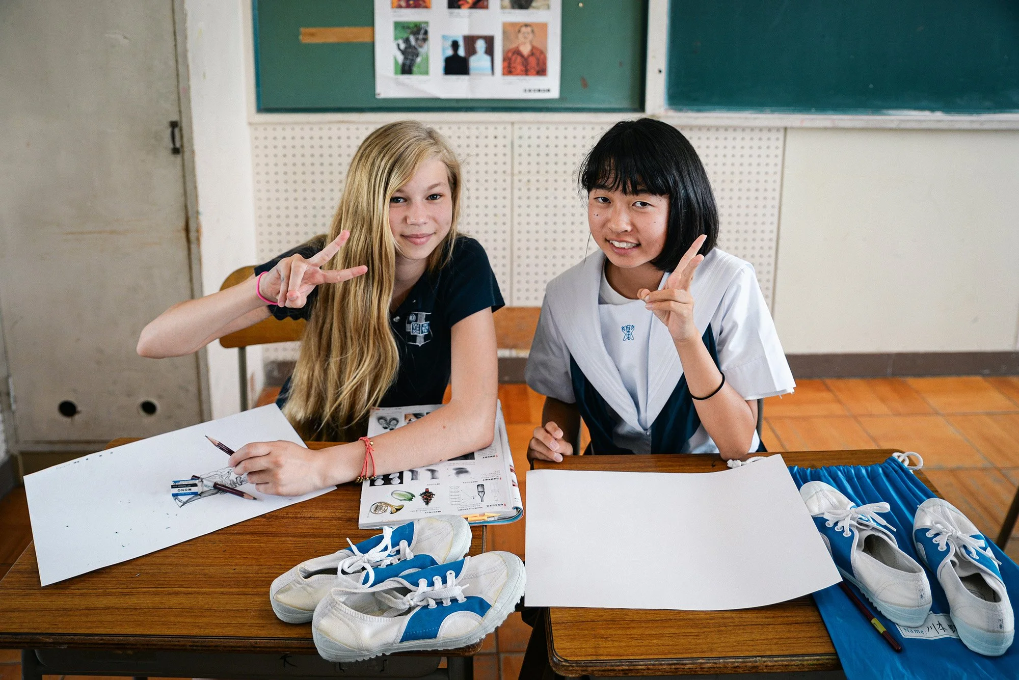American and Japanese junior high school student smiling while drawing at school in Japan