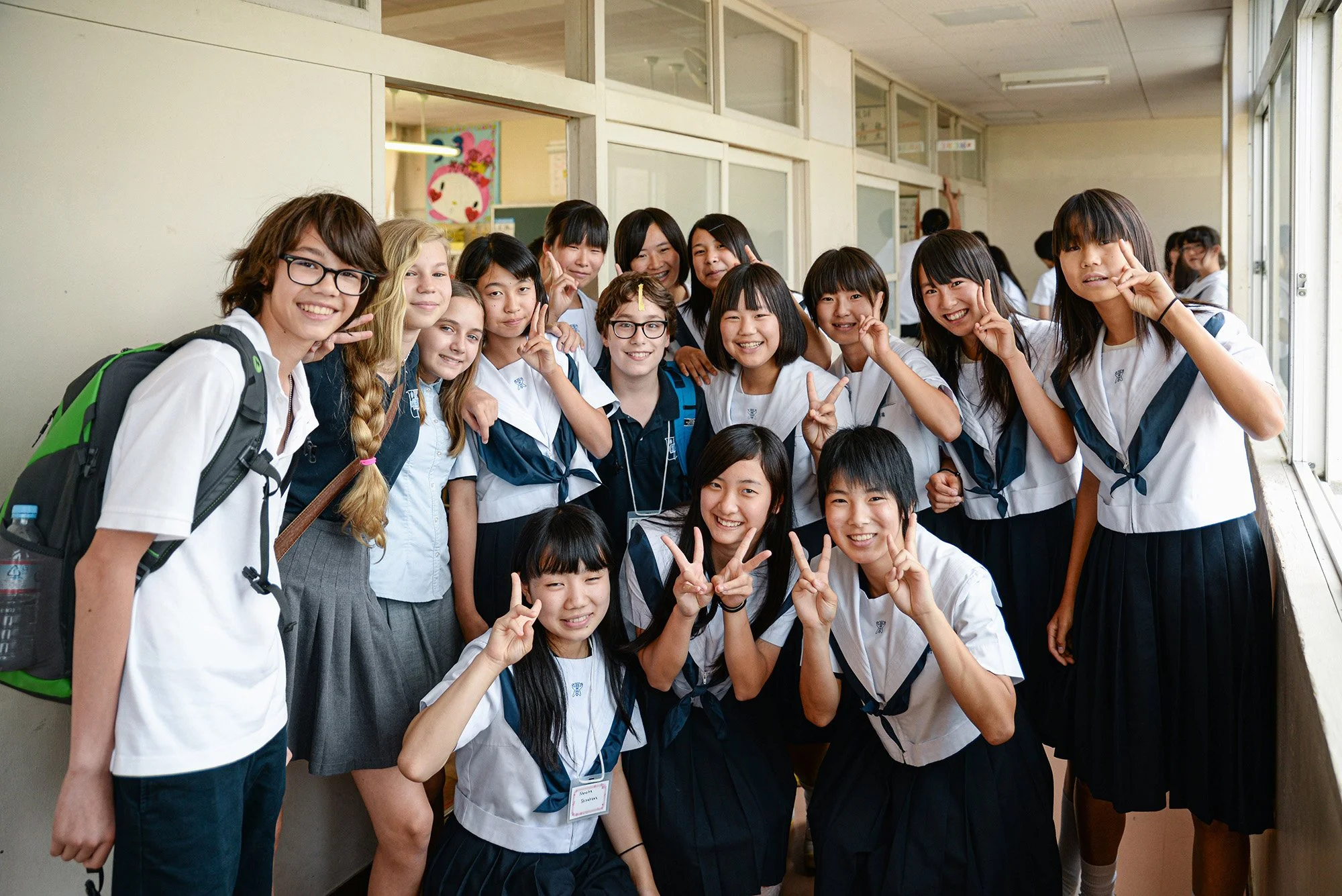 American and Japanese junior high school students smiling together at school in Japan