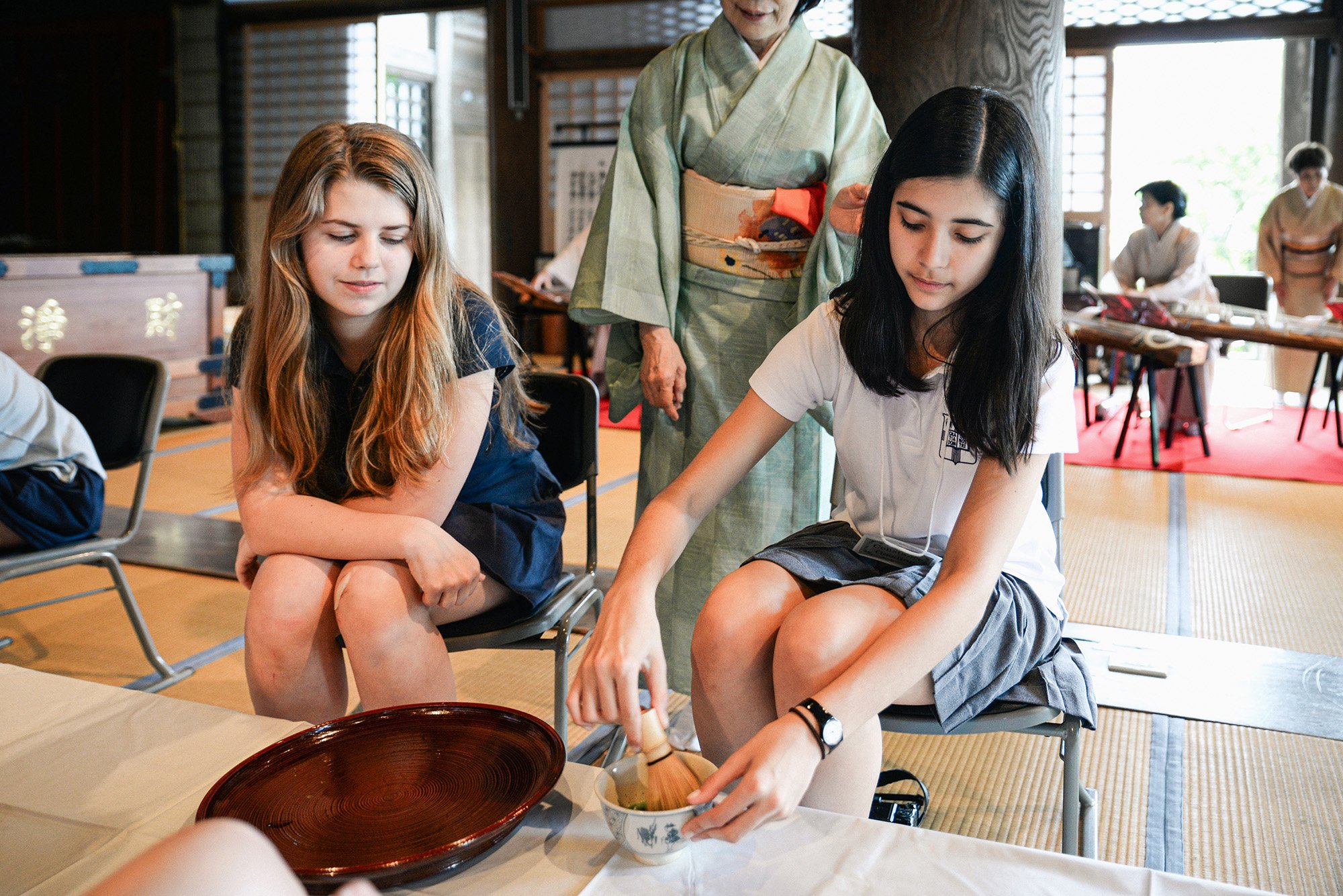 American student whisking matcha in a temple in Japan