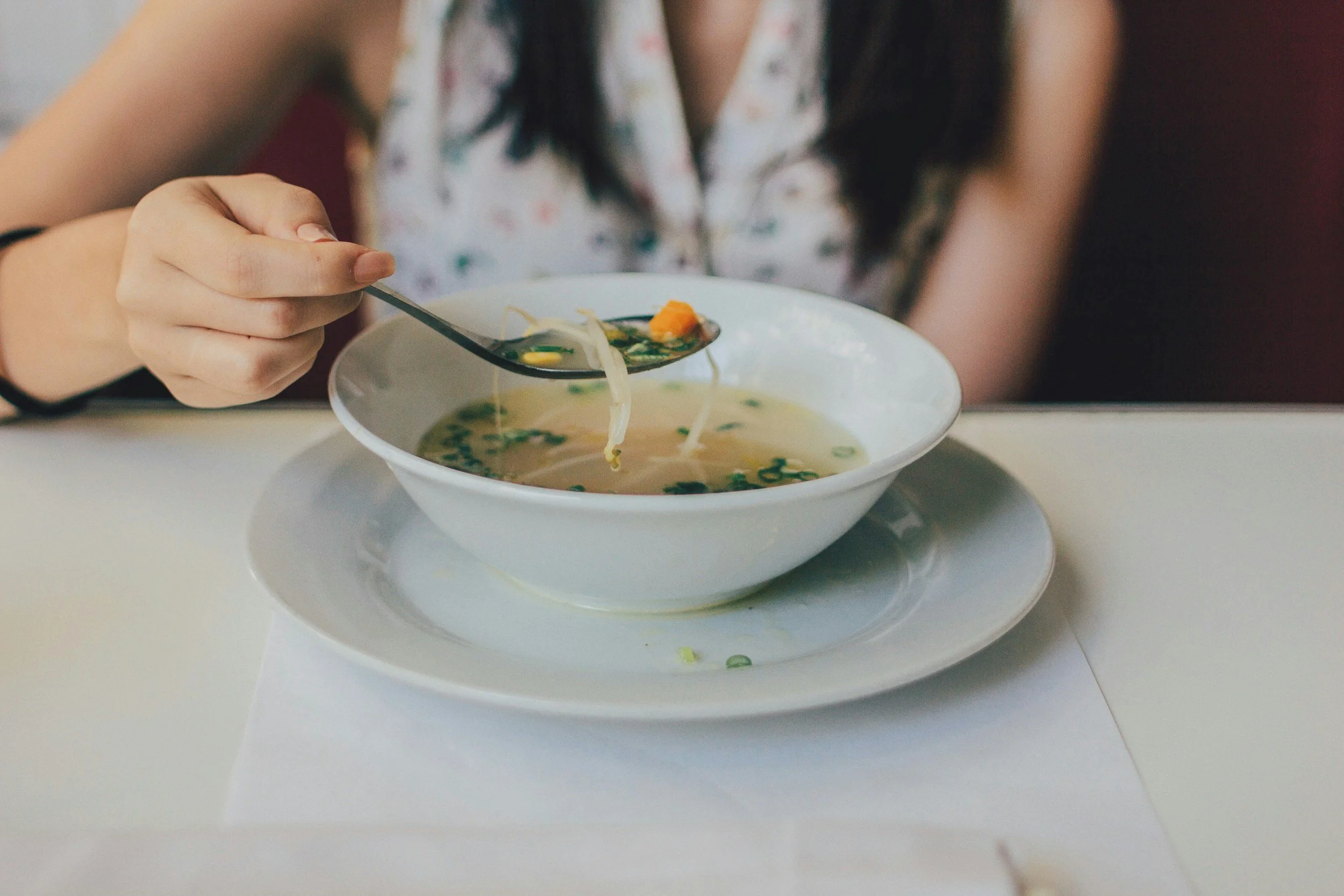 a new mum eats a bowl of Game-Changing Postpartum Chicken Broth