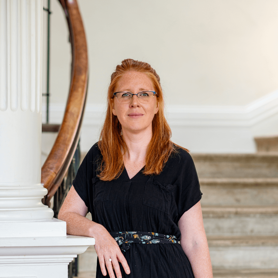 Gemma Kitto from Born to Birth Cornwall stands on a staircase smiling calmly and confidently before delivering her group antenatal class in Truro
