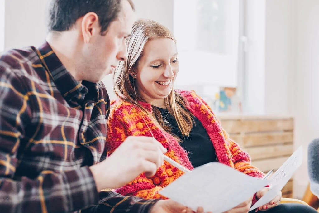 an expectant couple smile at their antenatal class in truro