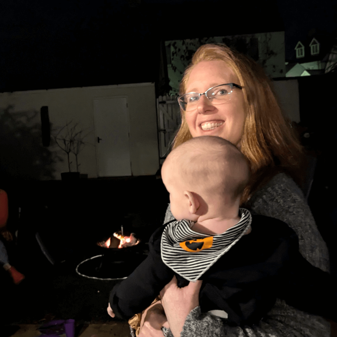 Gemma Kitto from Born to Birth Cornwall holding the baby of a postnatal doula client at a celebration event