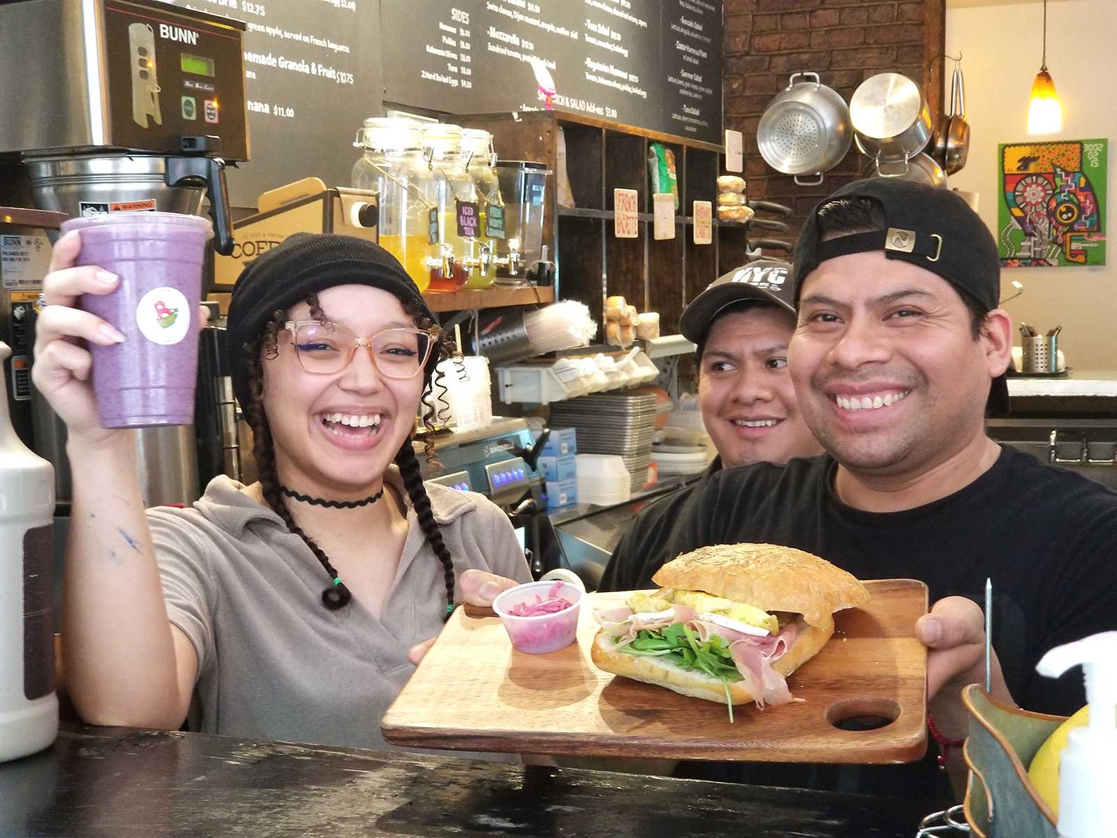 Employees presenting our Granola Shake and Eggs on Ciabatta Sandwich.