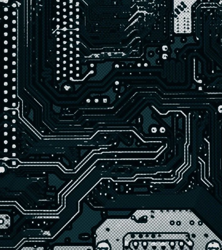 Close-up of a black printed circuit board with white electronic circuit traces and components.