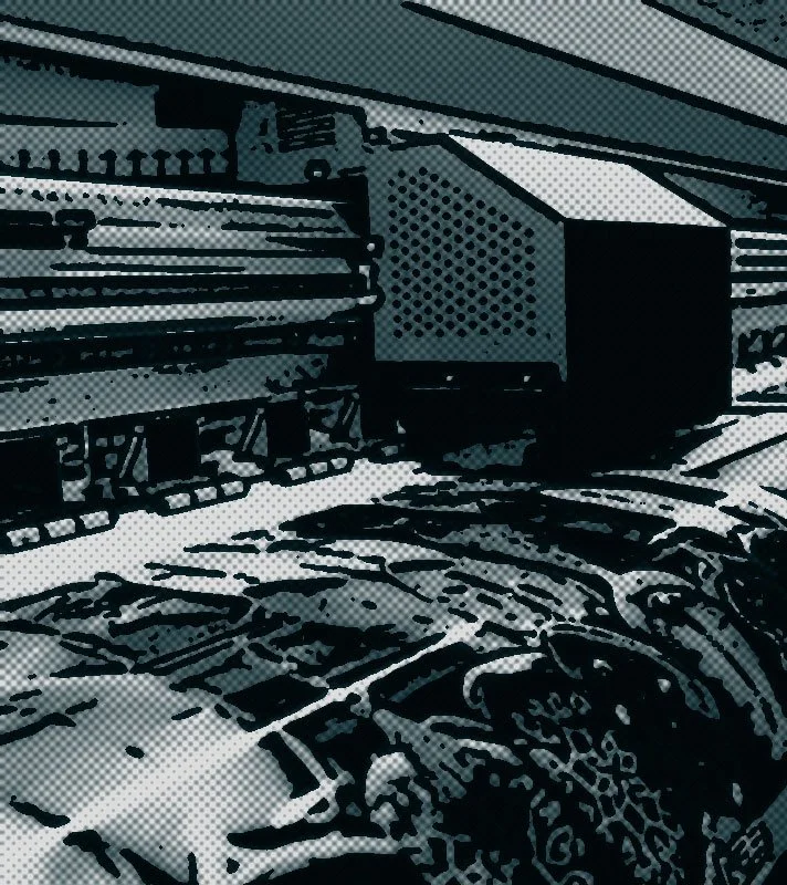 Close-up of a film camera on a track, with film reels and parts of a film set background.