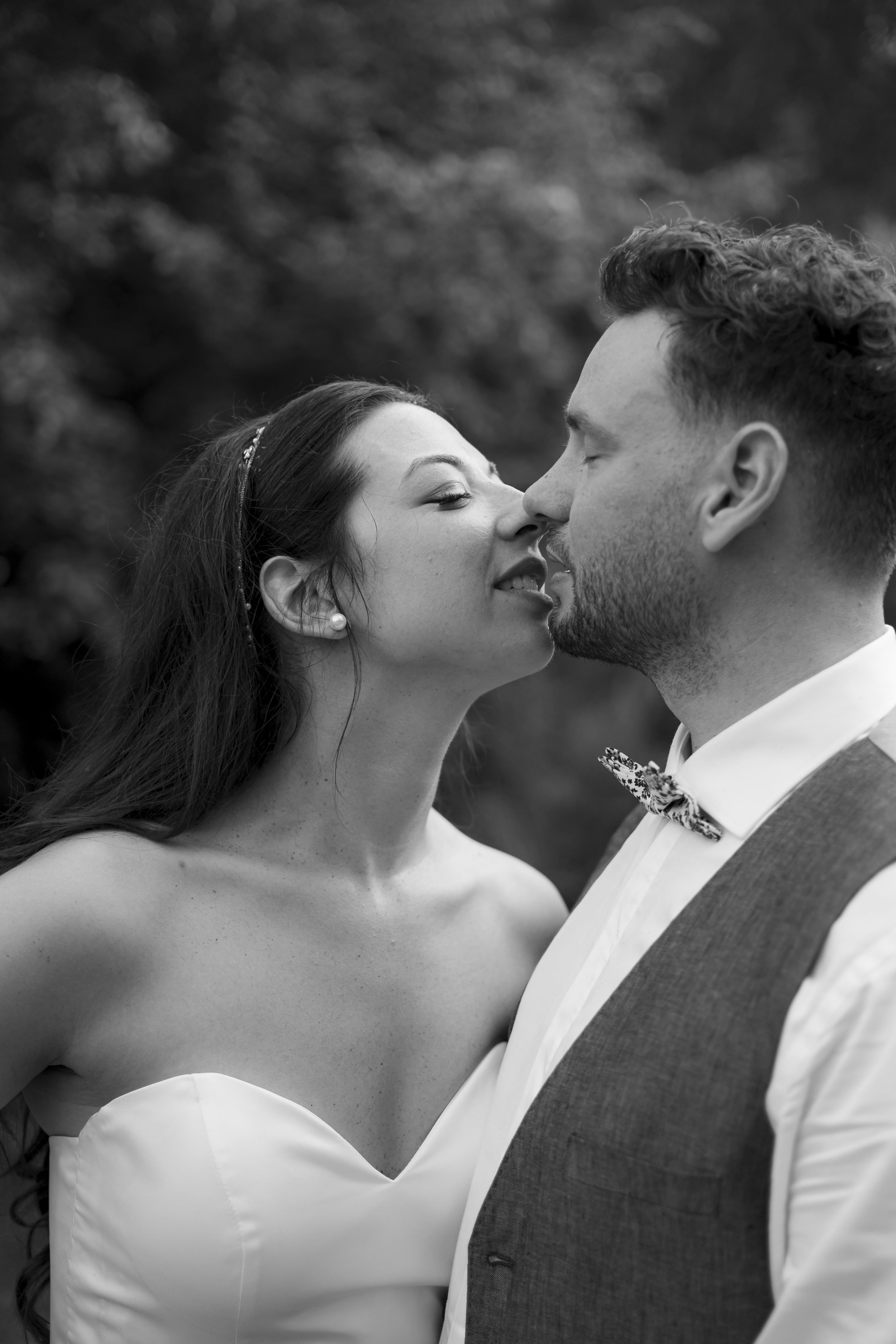 une mariée prête à embrasser son époux en noir et blanc