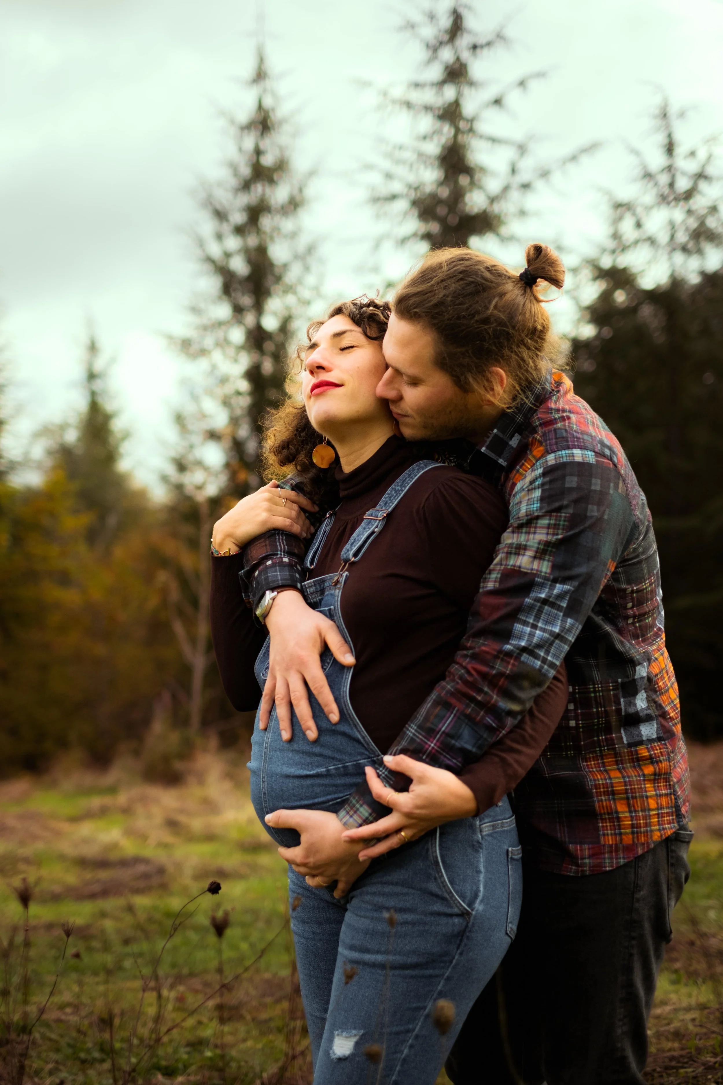 homme qui enlace sa femme enceinte de dos
