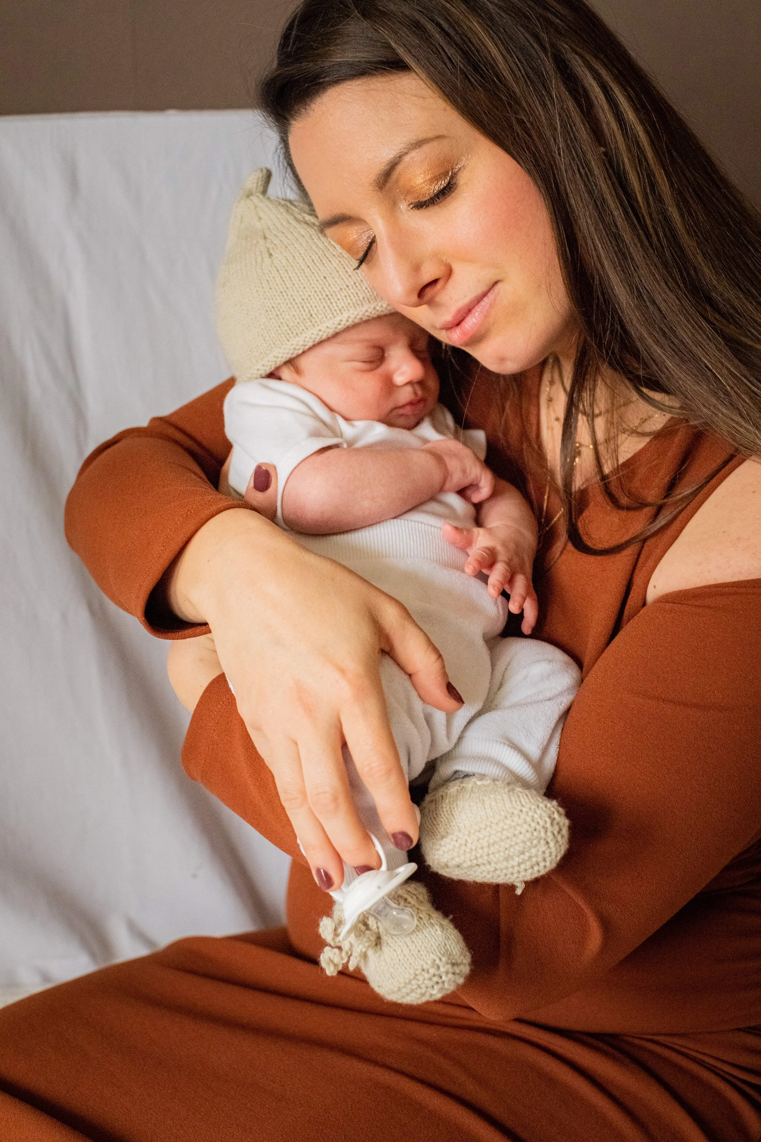 la maman avec son bebe dans les bras et le cajole 