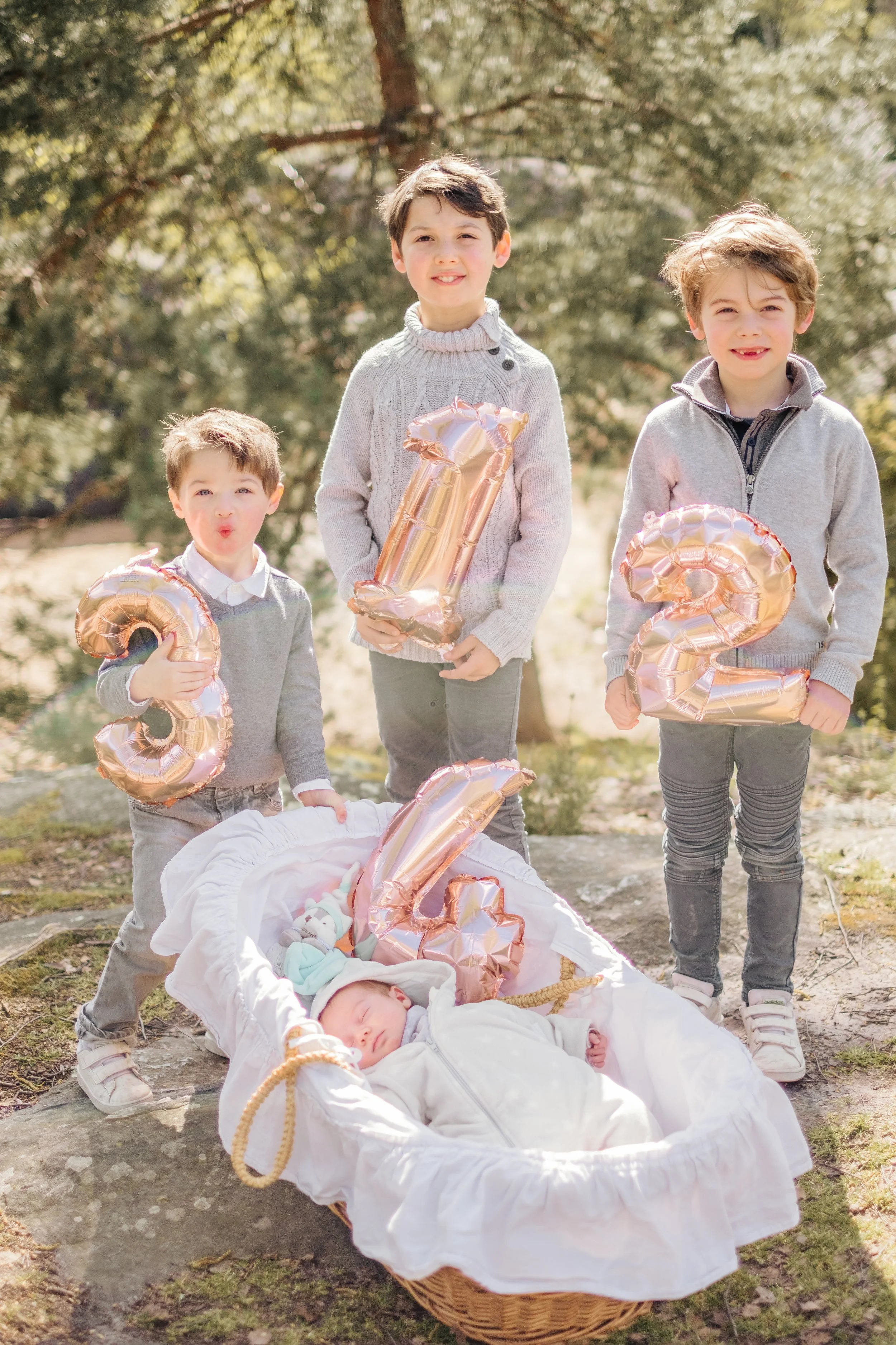 trois enfants autour du berceau de leur nouveau petit frere 