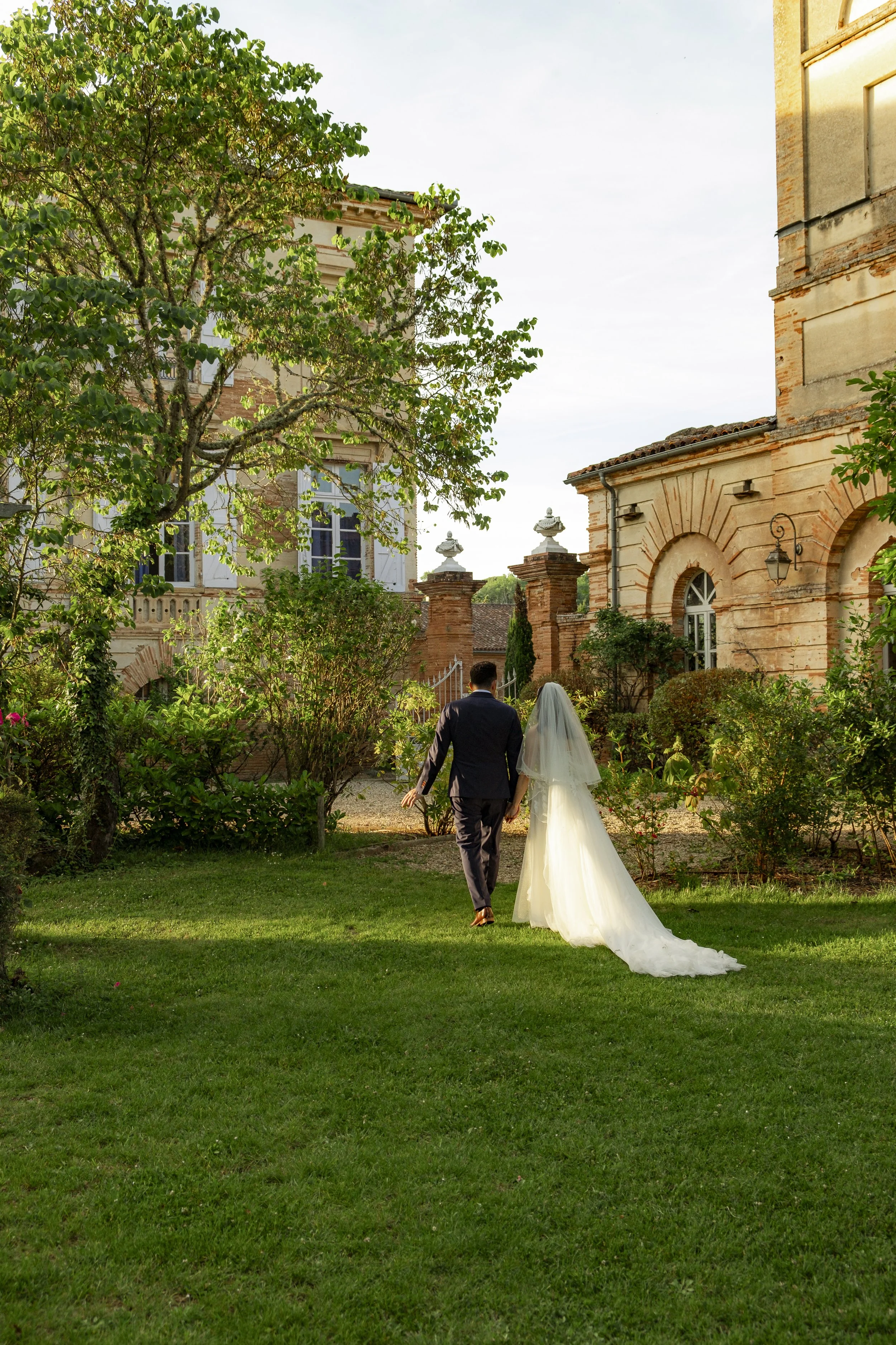 couple de mariés qui marchent vers leur domaine