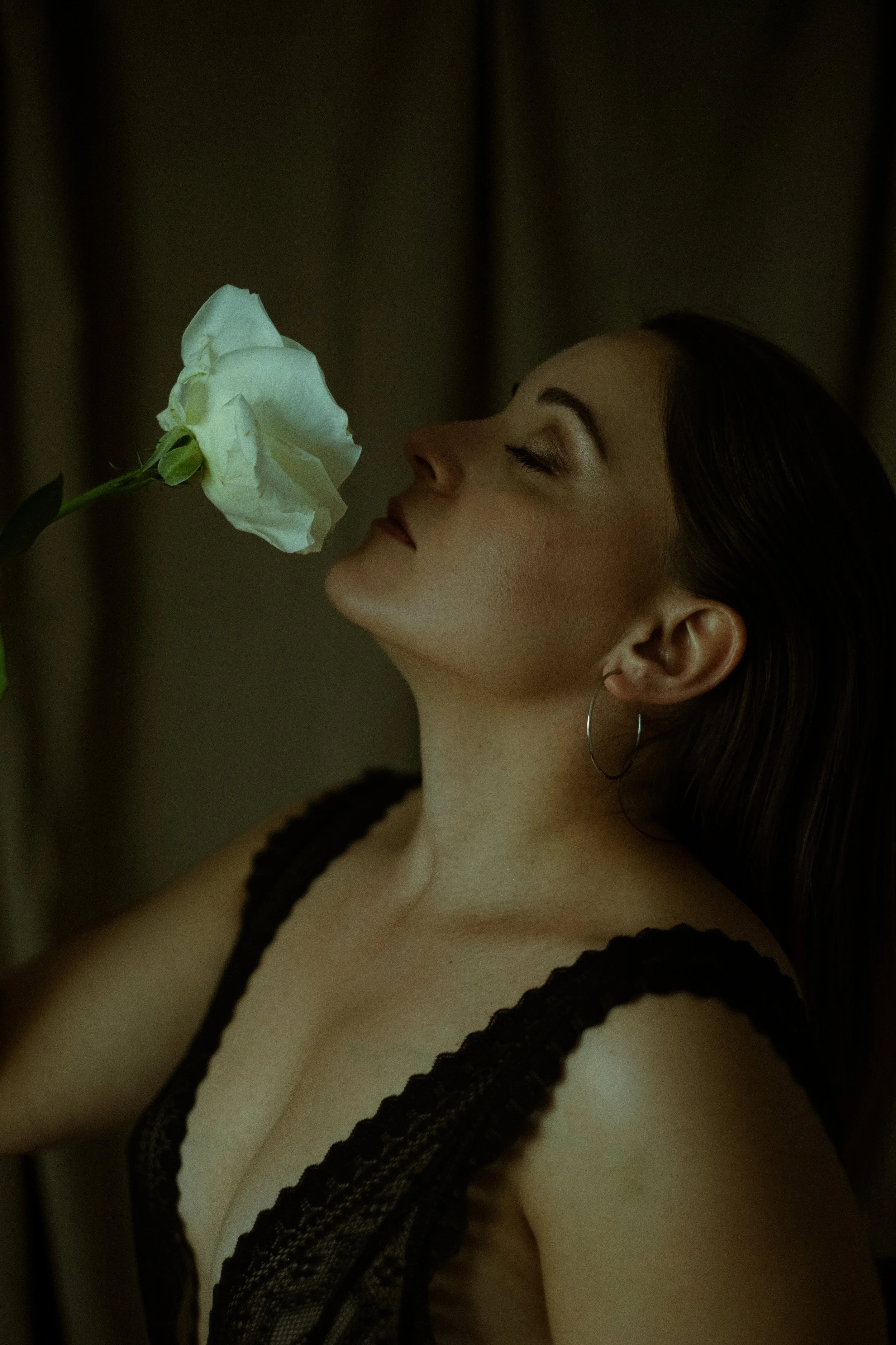 portrait dune femme en studio avec une rose blanche en lingerie