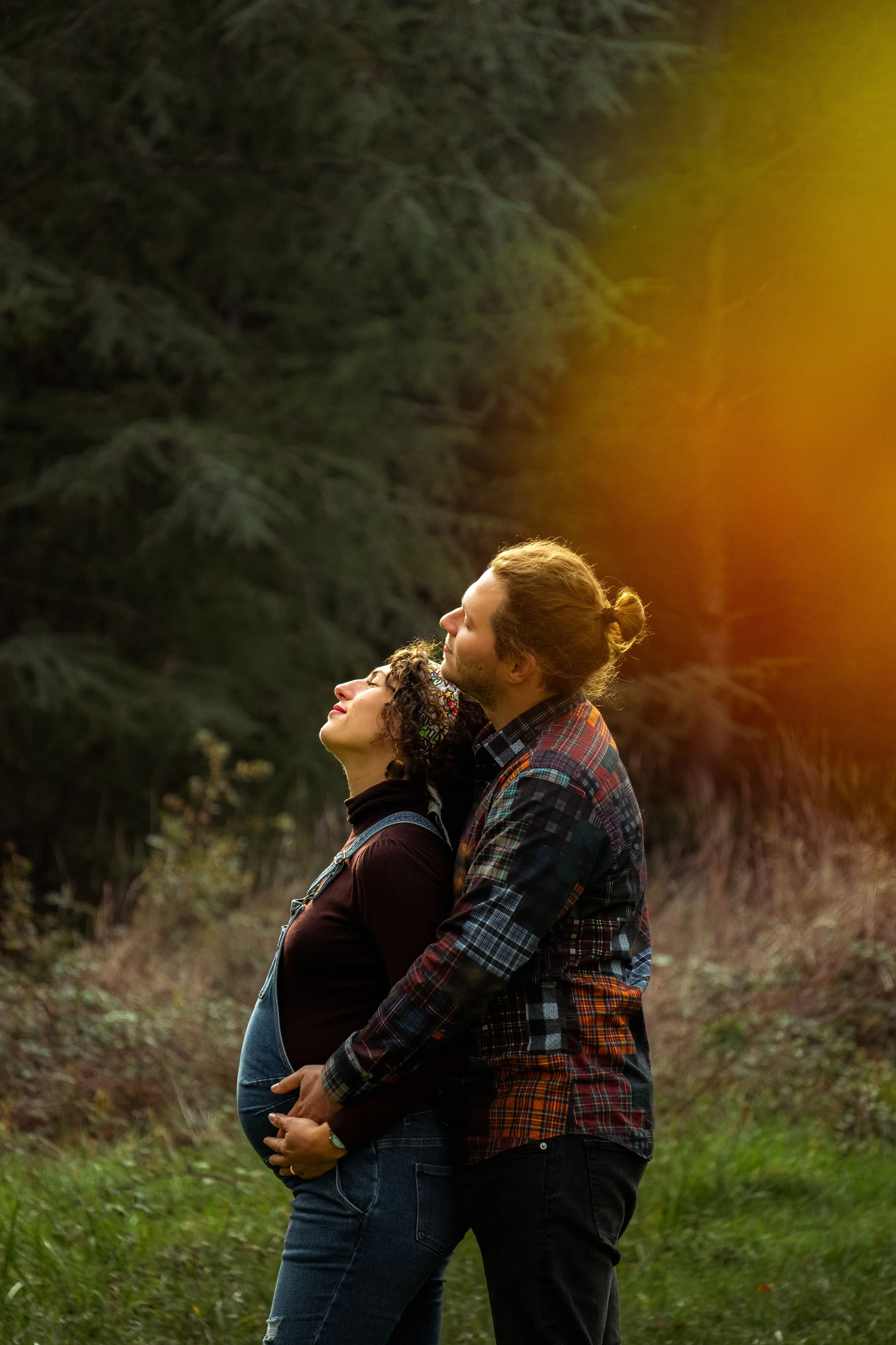 homme et femme enceinte de profil qui se font un calin 