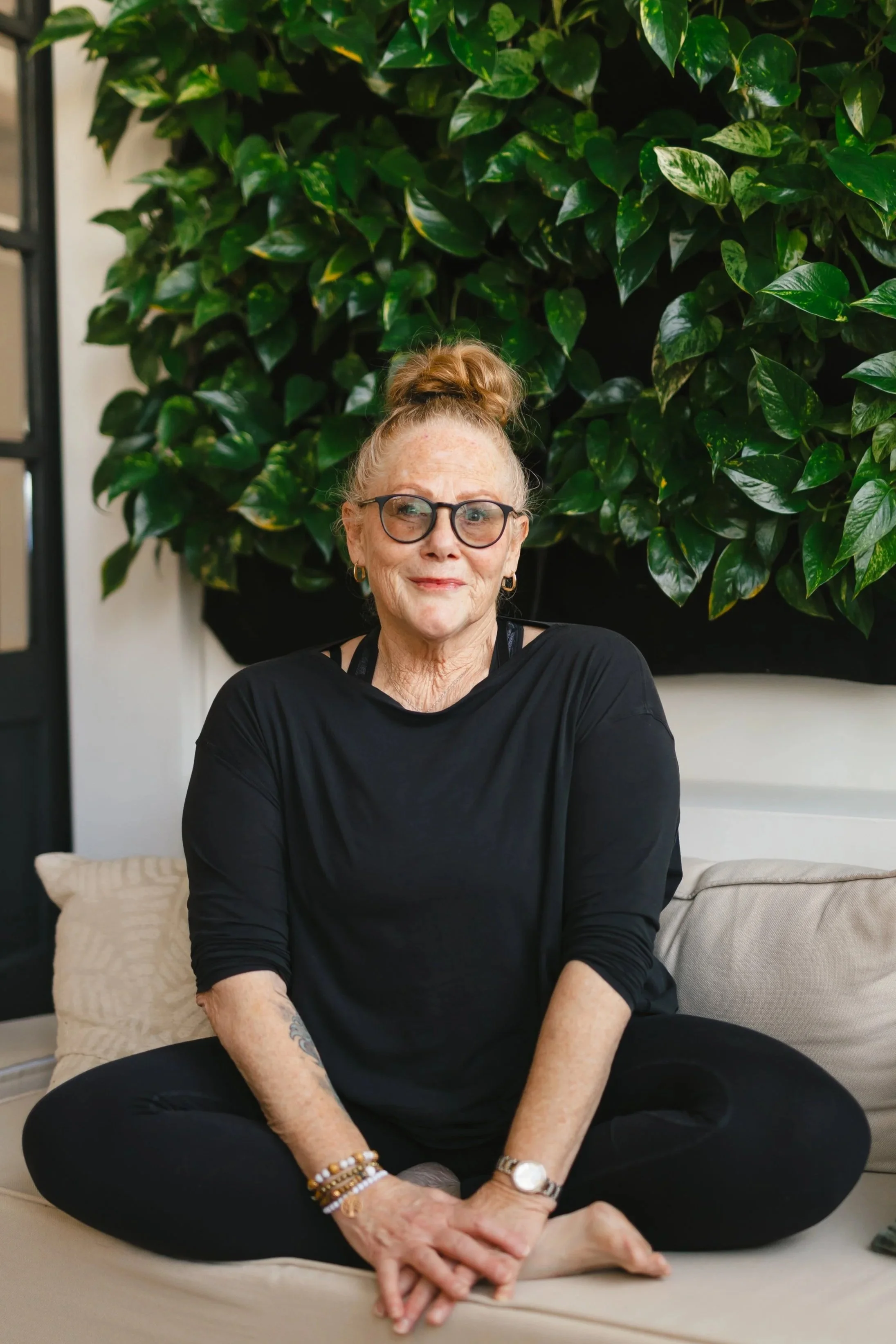 annette mellor siting criss cross apple sauce on a couch | &asanas hot yoga and pilates studio in london, ontario