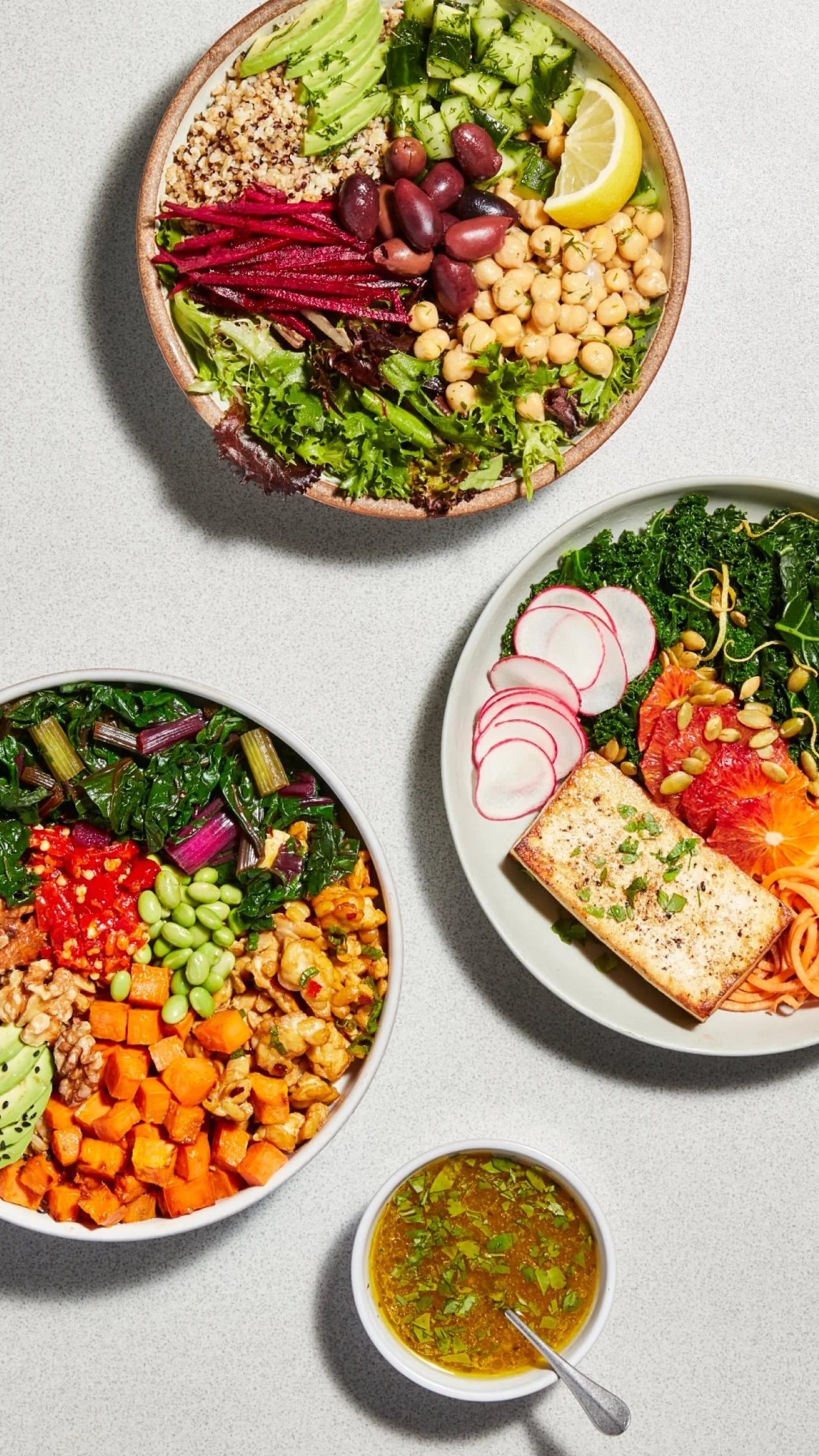 3 plates and a bowl of healthy vegan food from a birds eye view | &asanas hot yoga and pilates studio in london, ontario