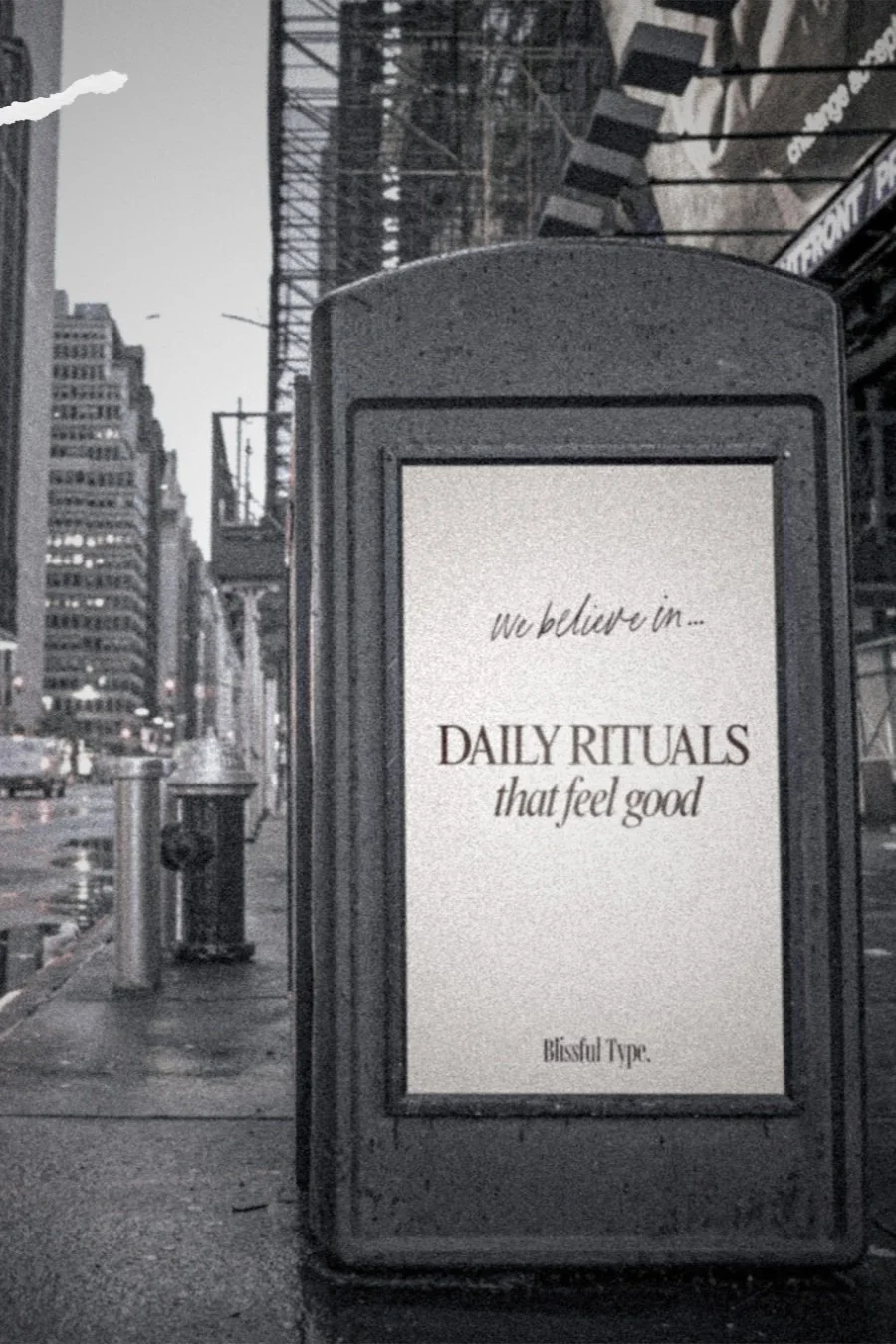 Blissful Type billboard in a moody city street with the affirmation “Daily rituals that feel good,” promoting mindful routines, intentional living, and self-care for women. he urban setting contrasts with the calming wellness message