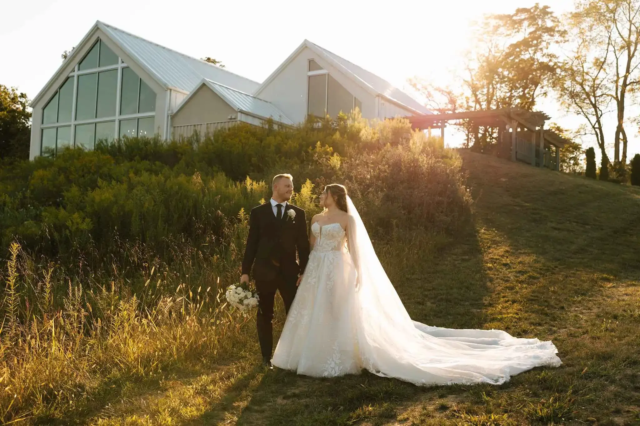 Countryside wedding venue exterior overlooking rolling hills at sunset