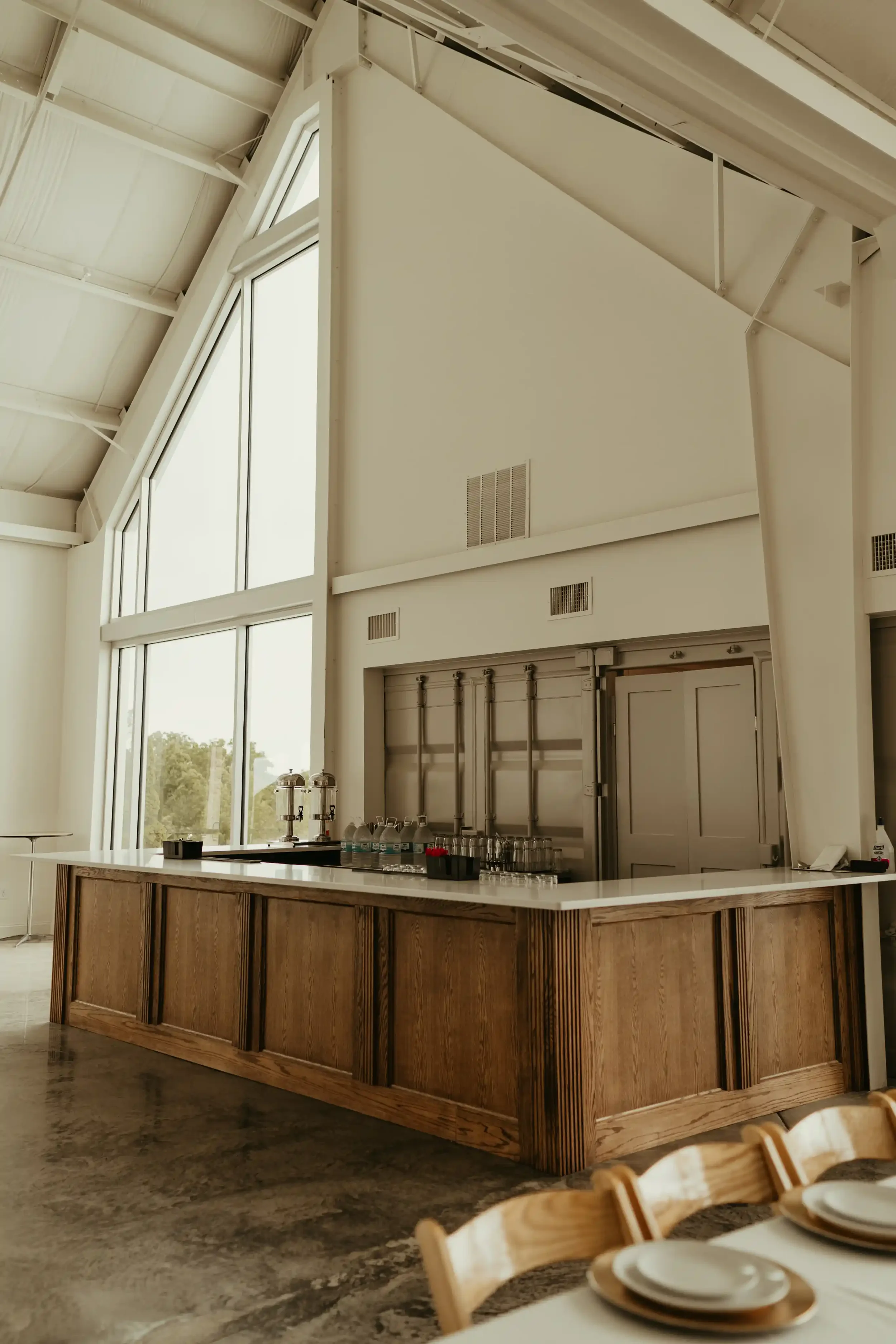 Spacious interior bar with vaulted ceiling and floor-to-ceiling windows inside The Seventy Five event venue