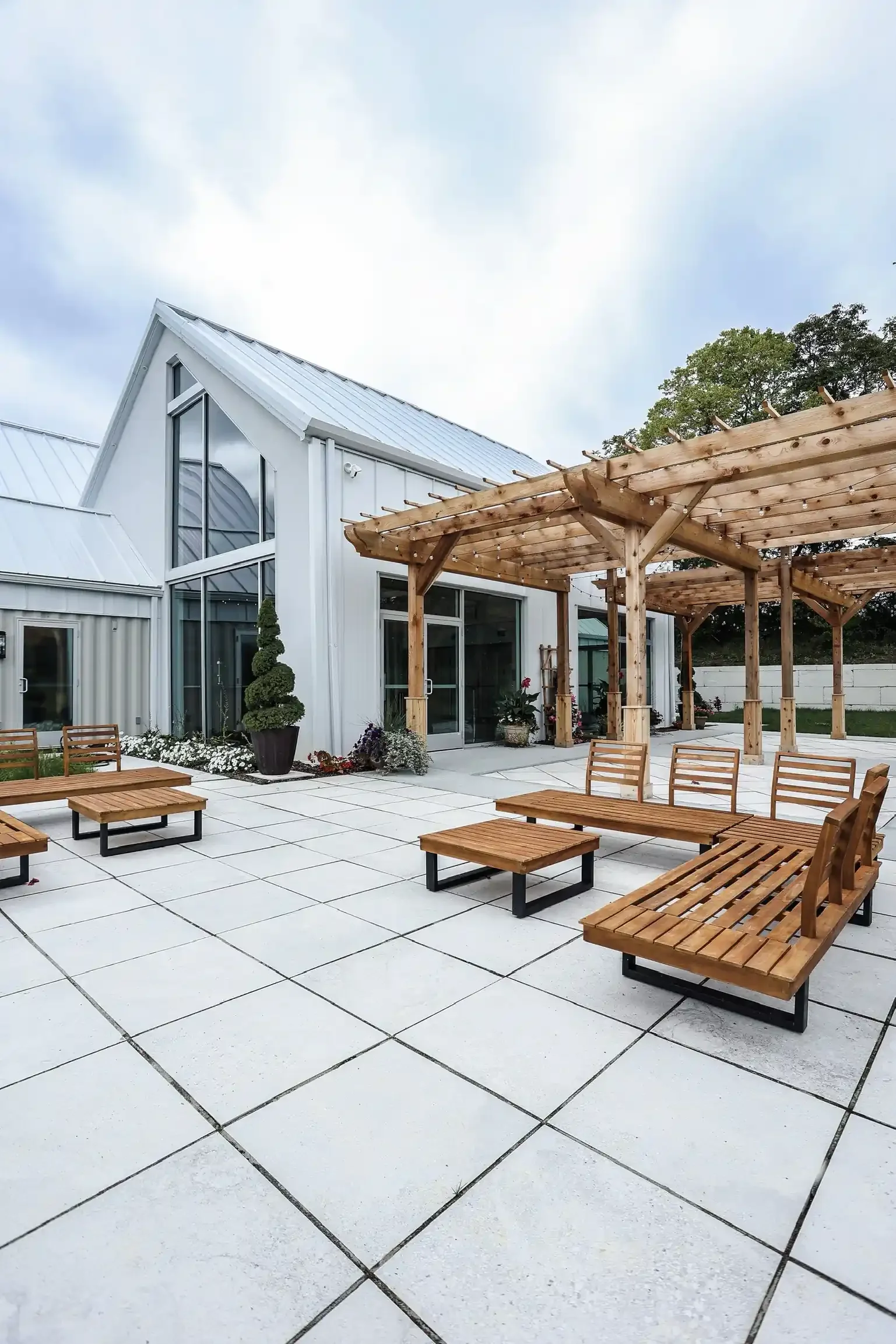 Modern outdoor patio with wood pergola and teak lounge furniture at The Seventy Five event venue