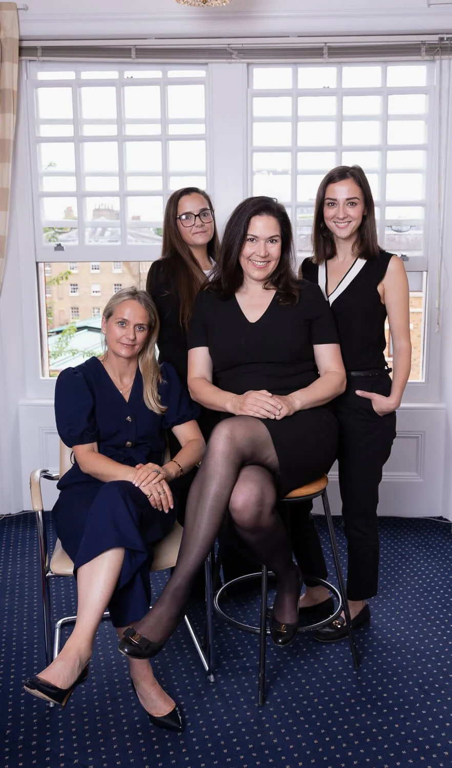 Team shot of Female doctors posing against a window