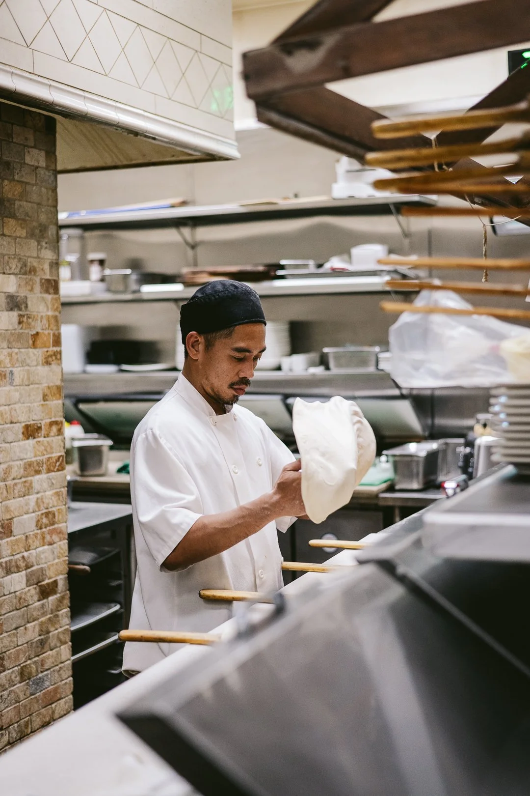 chef preparing pizza in a restaurant kitchen