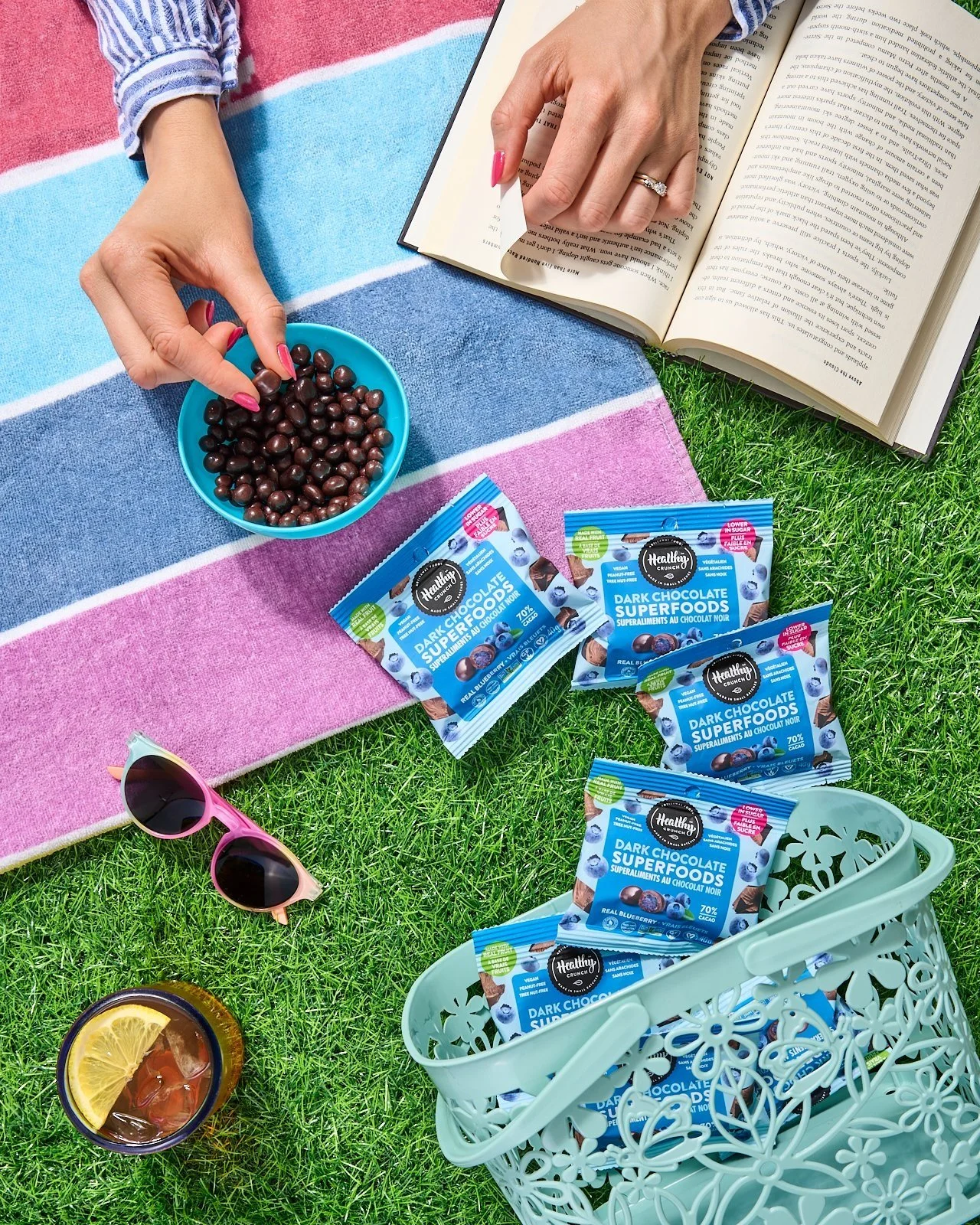a person reading a book and snacking on chocolate treats outside on the grass