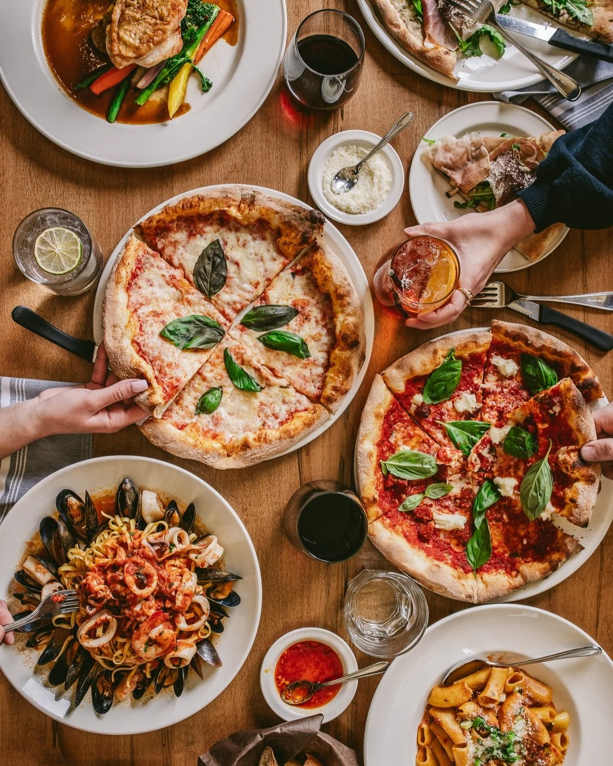 tablescape at a restaurant with pizzas and pastas