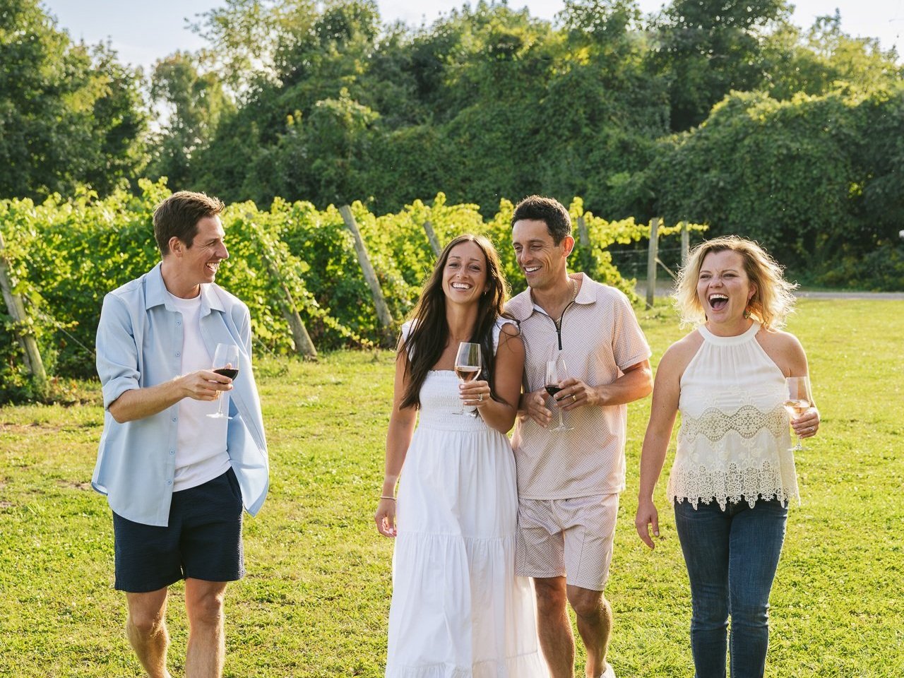 group of friends in a winery cheersing and laughing